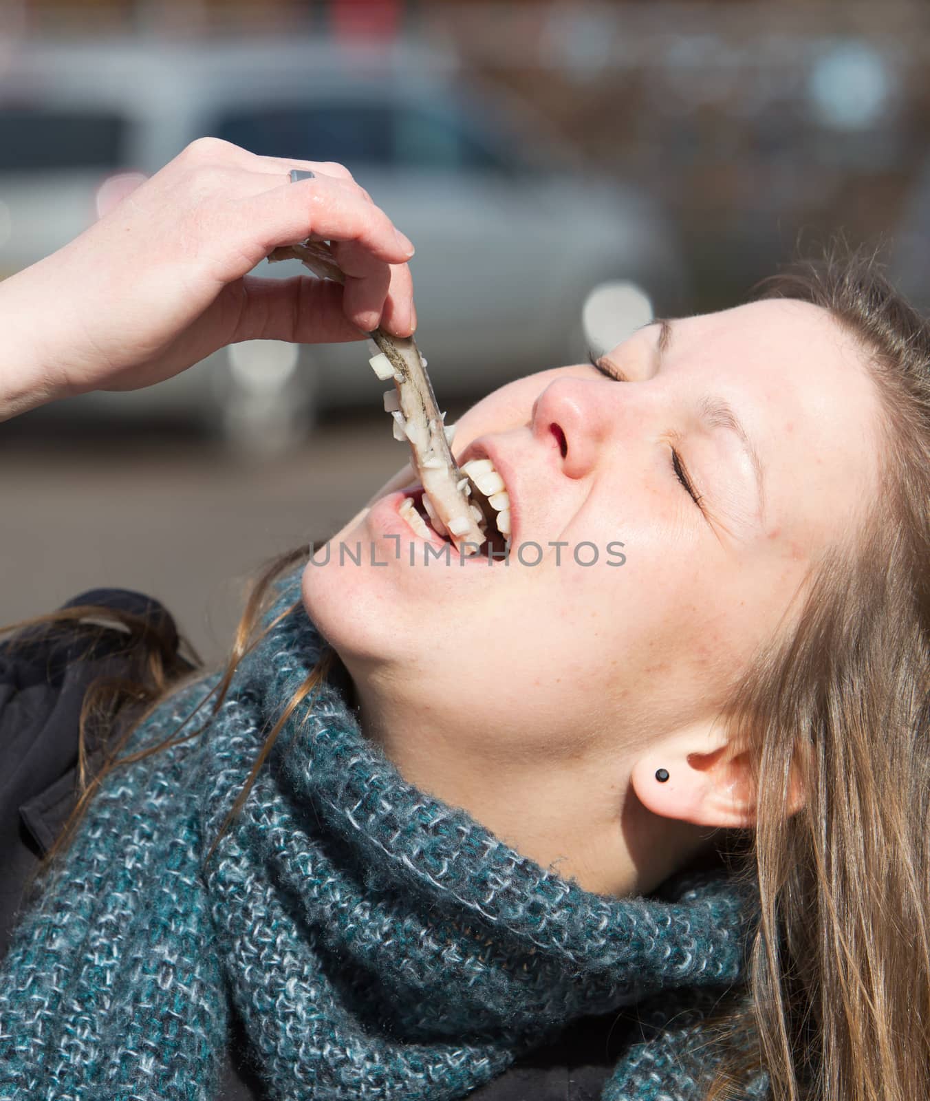 Dutch woman is eating typical raw herring with onions