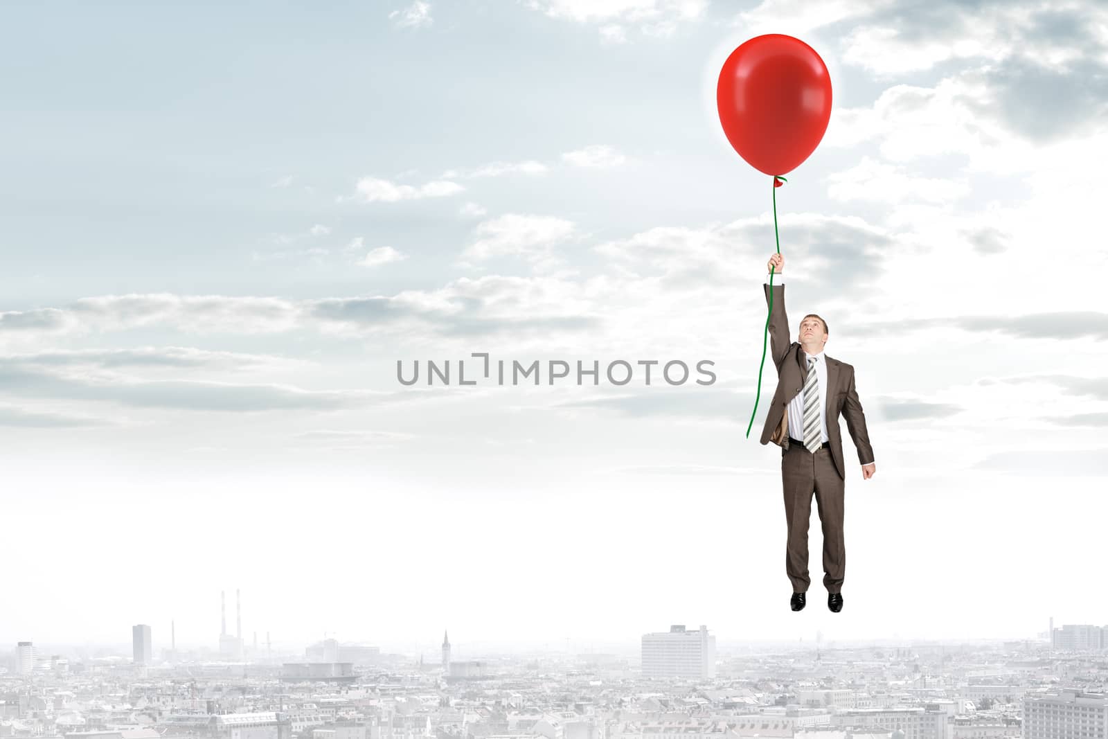 Businessman holding red balloon and flying above city, business concept