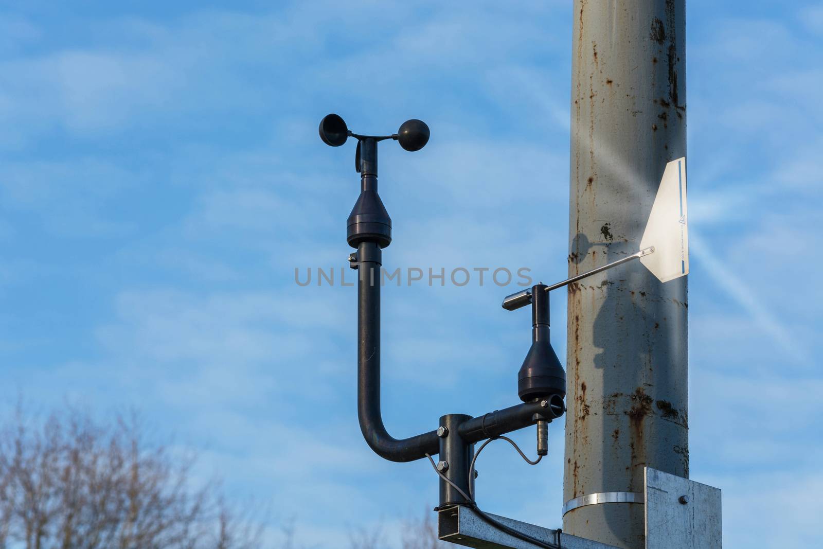 Weather station with anemometer on blue sky.