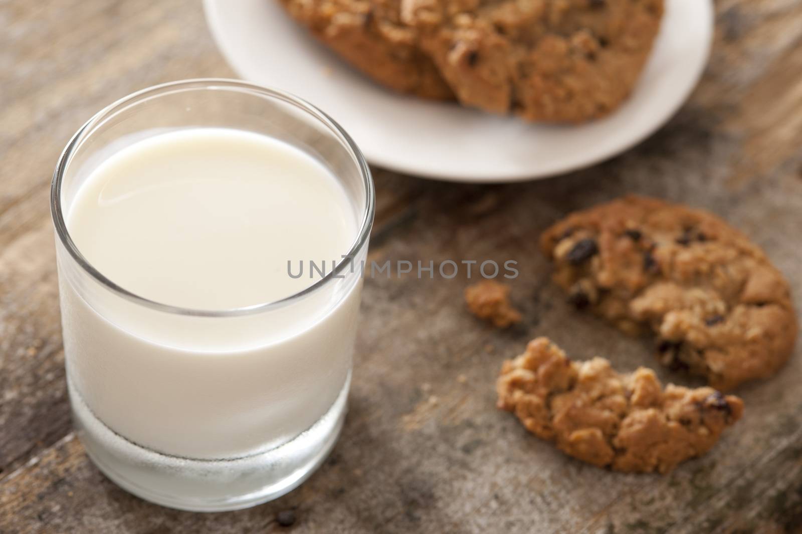 Glass of fresh milk with cookies by stockarch