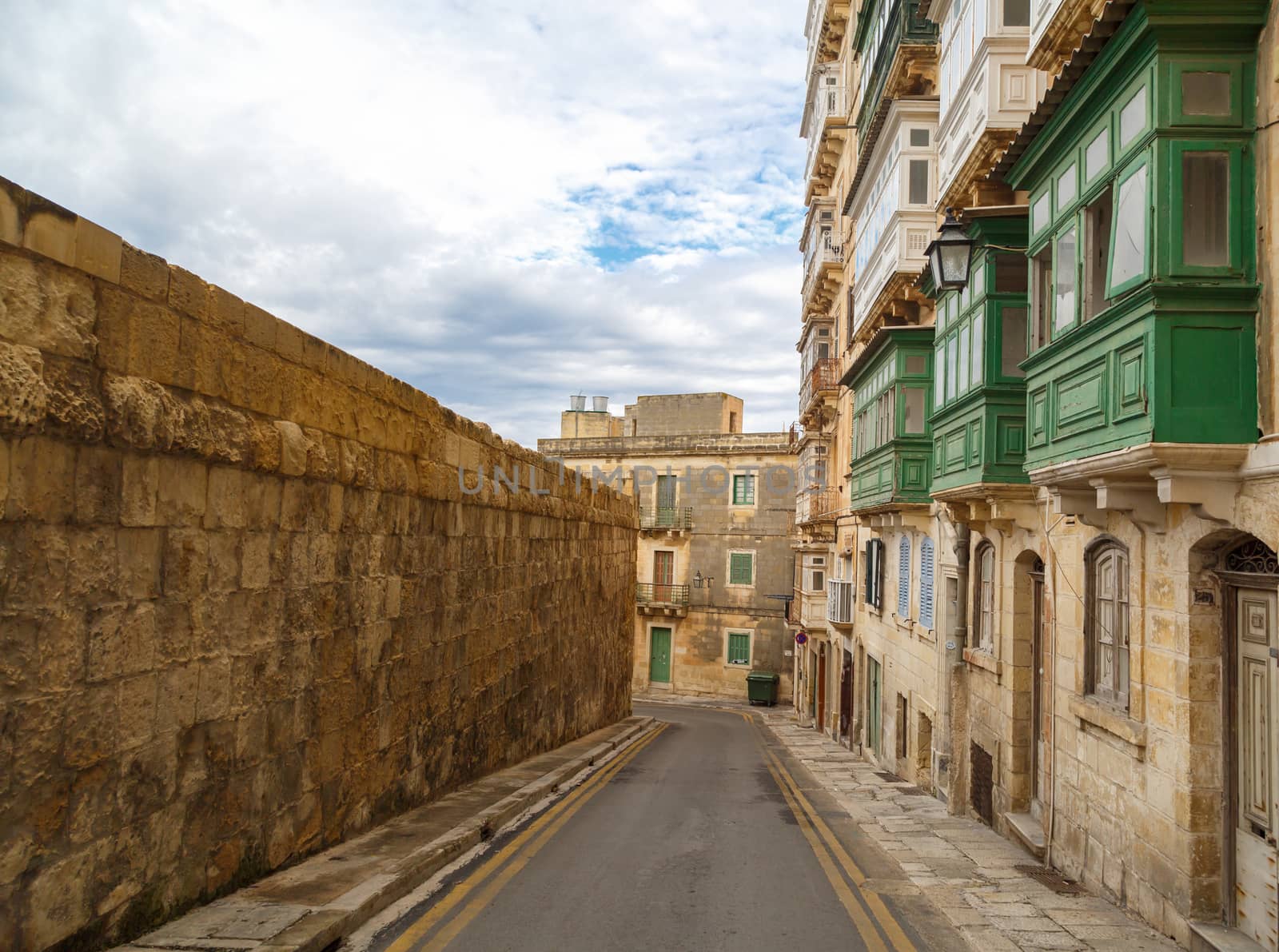 Detailed view of Valletta city in Malta island with limestone buildings from medieval times, on cloudy sky background.