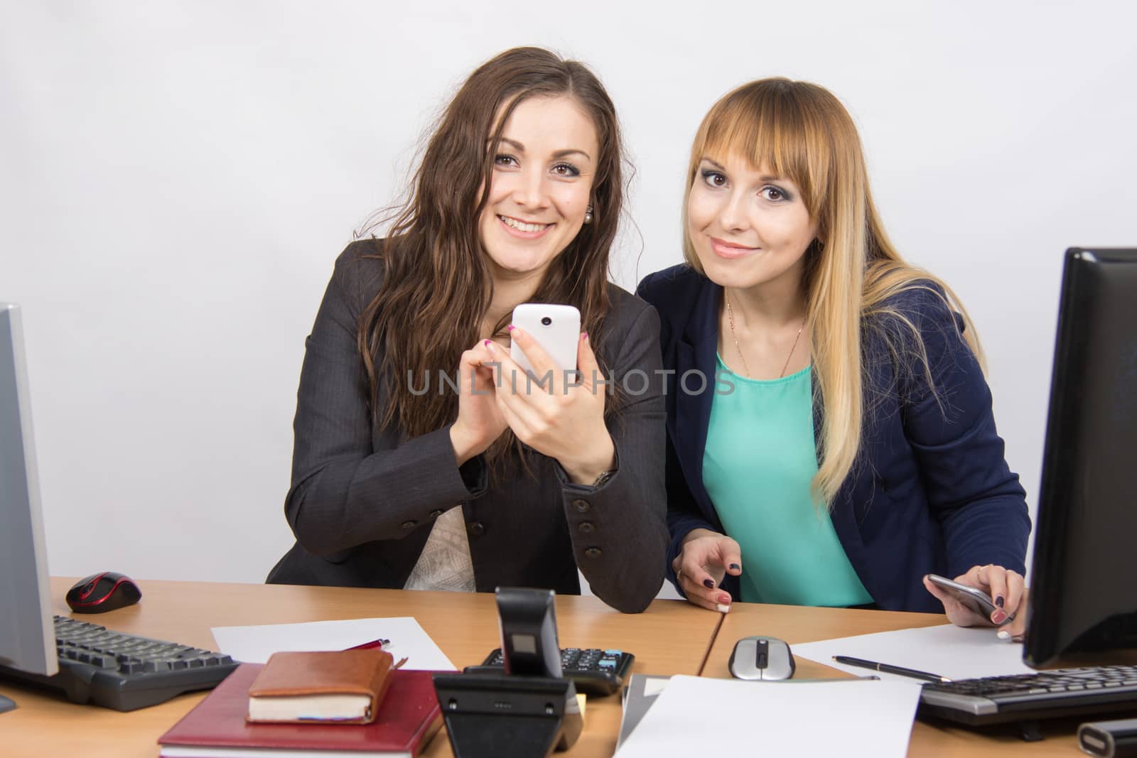 Office workers looking lively in the cell phone at his desk by Madhourse