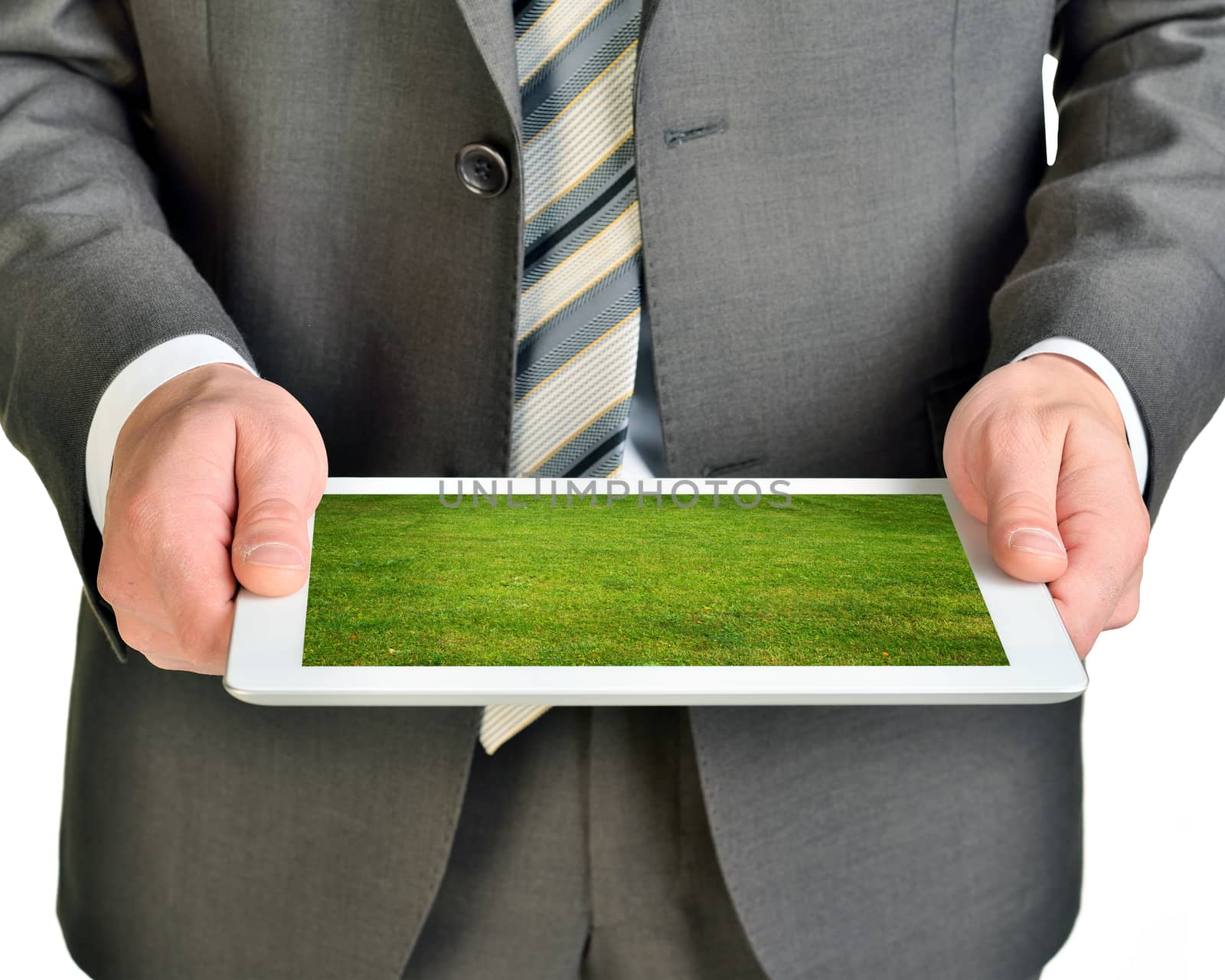 Businessman holding tablet with green grass isolated on white background