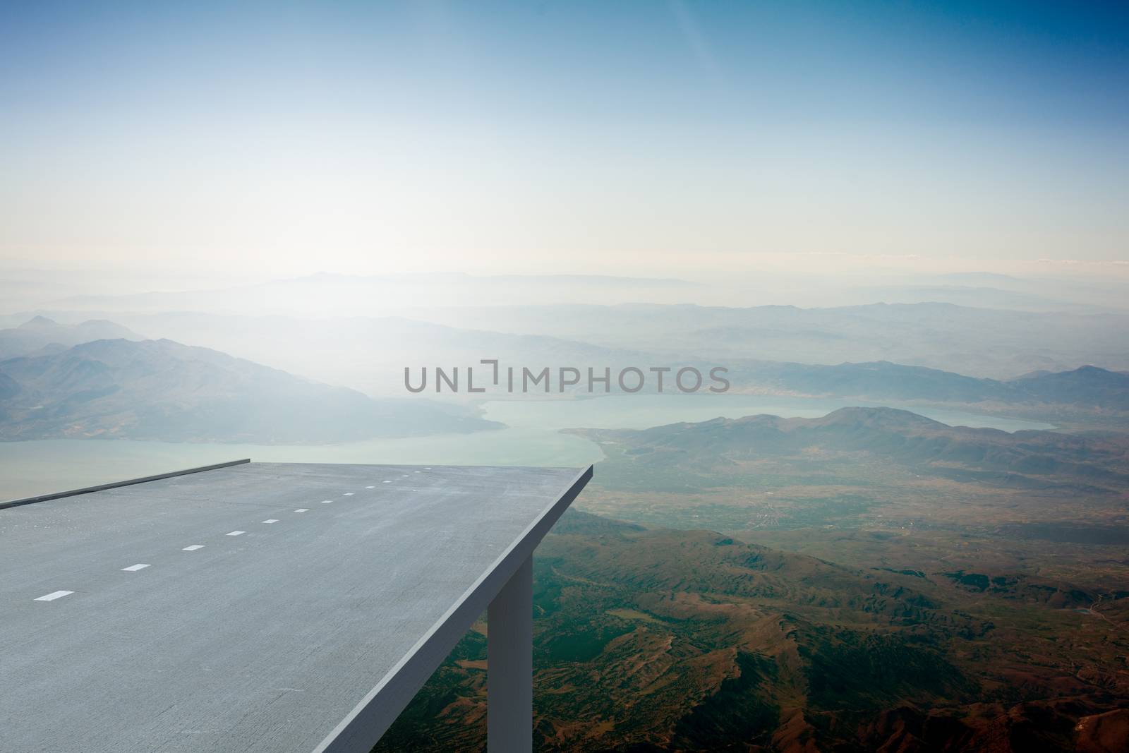 Road over mountains in blue sky and sun