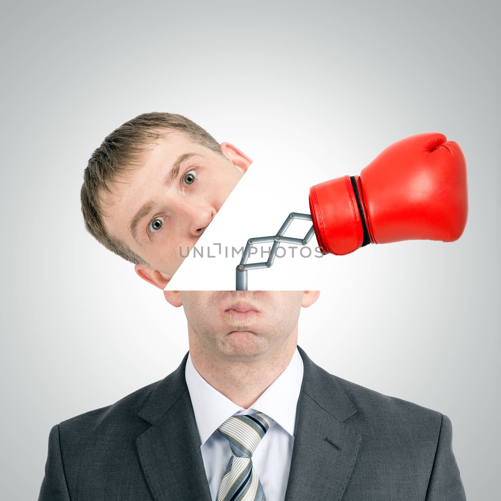 Boxing glove beating from businessmans head on grey background