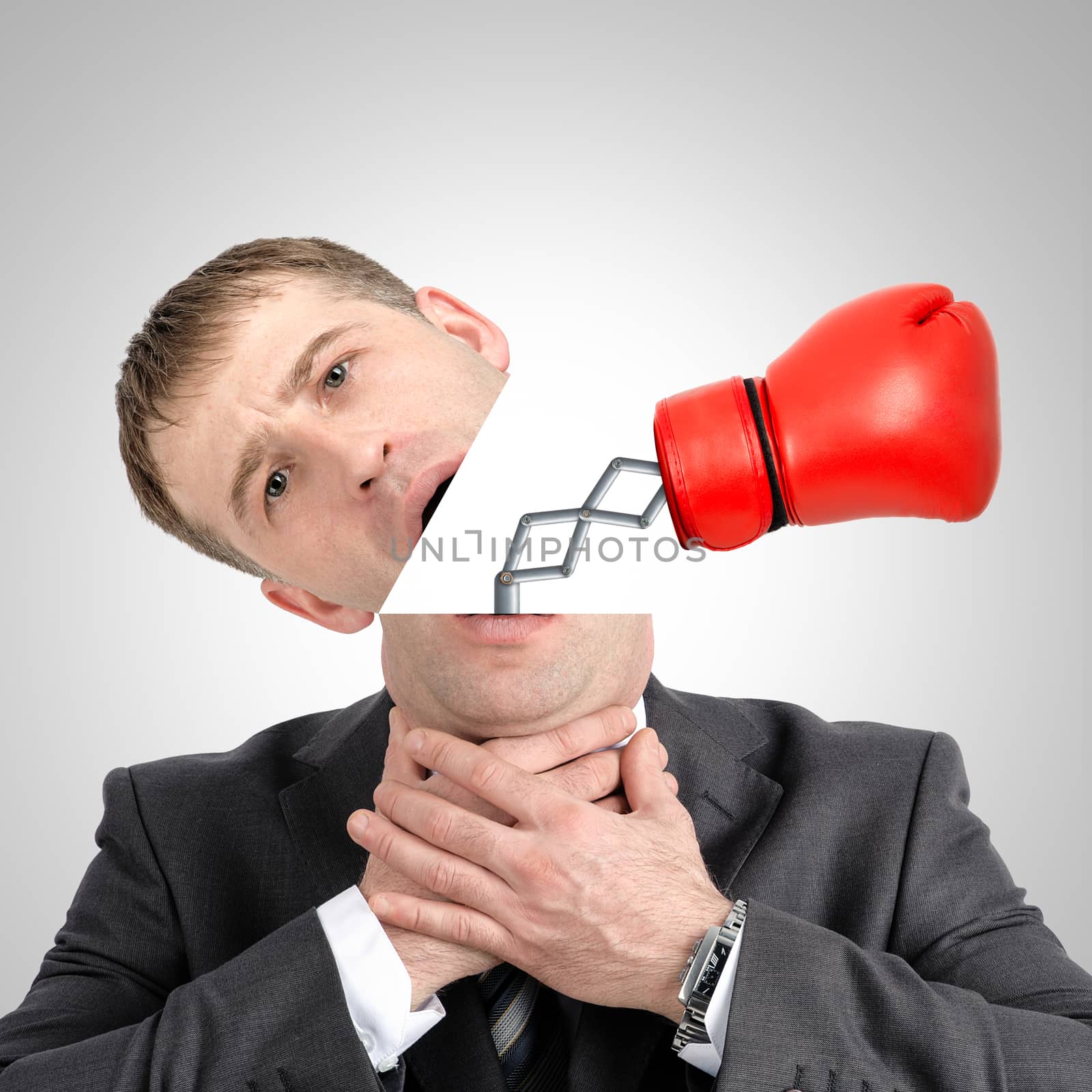 Boxing glove beating from businessmans head on grey background, close up view