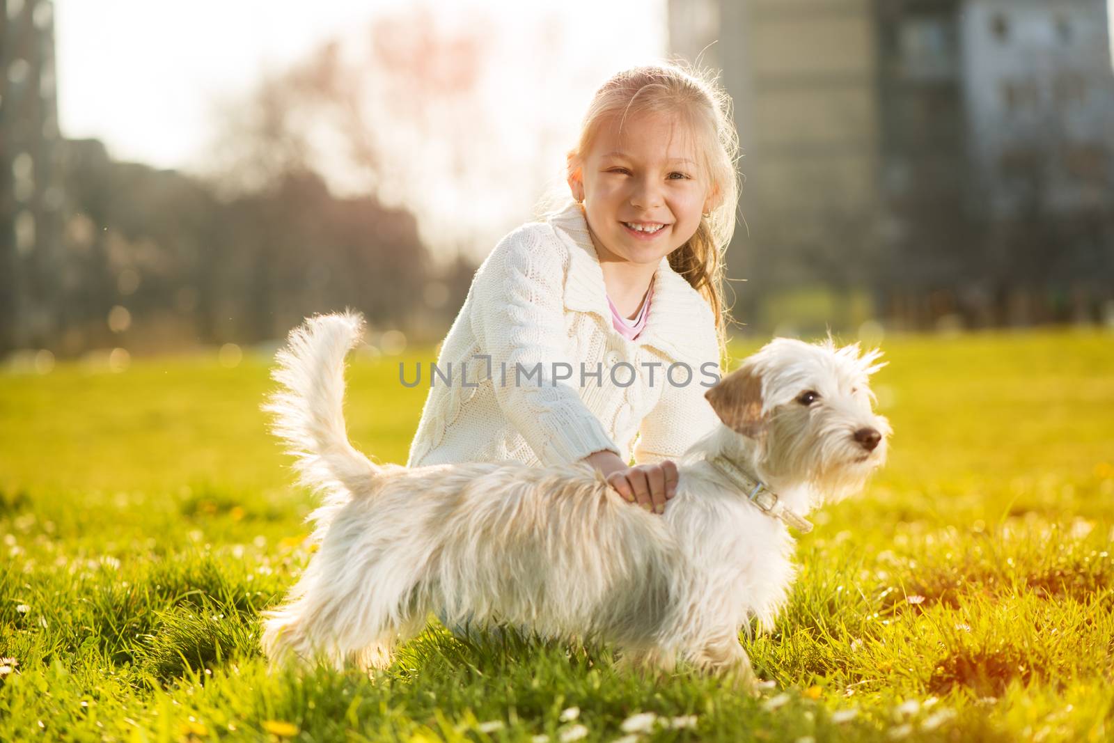 Little girl caress with her puppy dog in the park