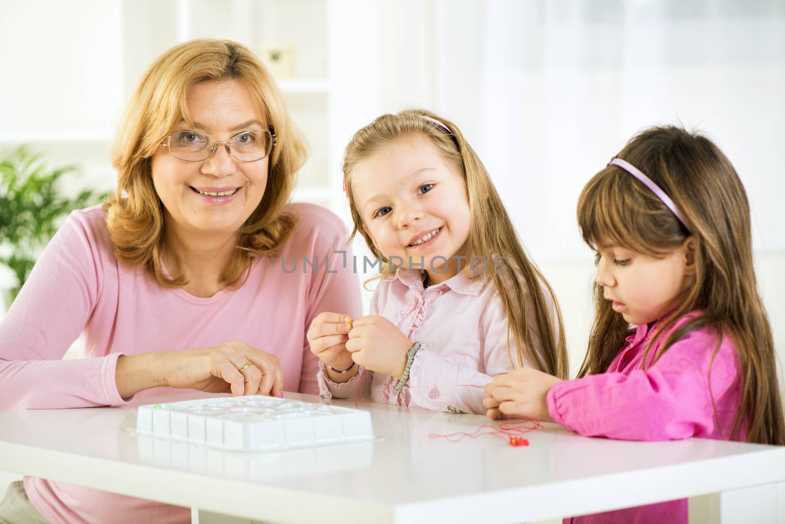 Two Young girls making bead bracelets