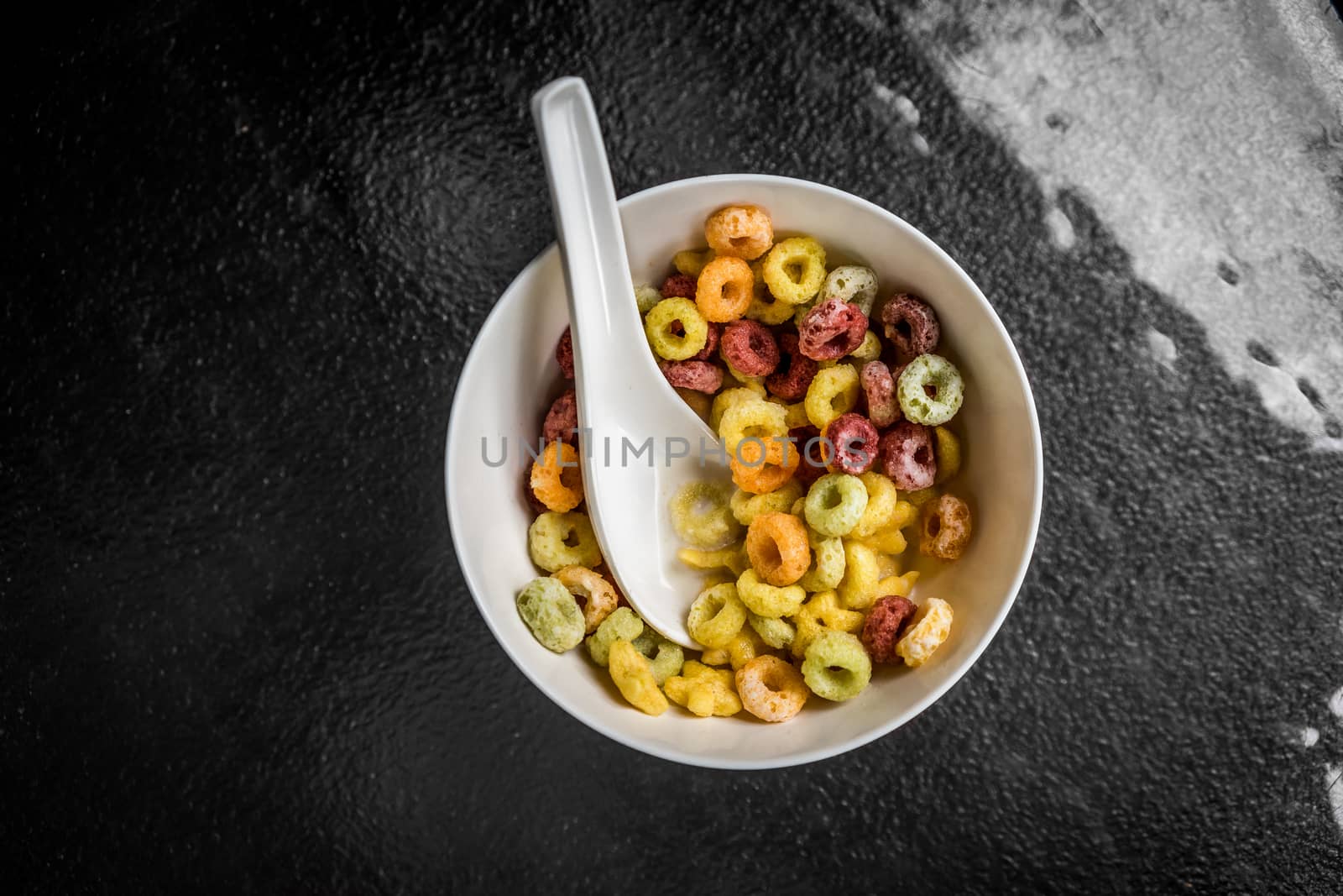 A top view shot of a bowl of colorful cereal.