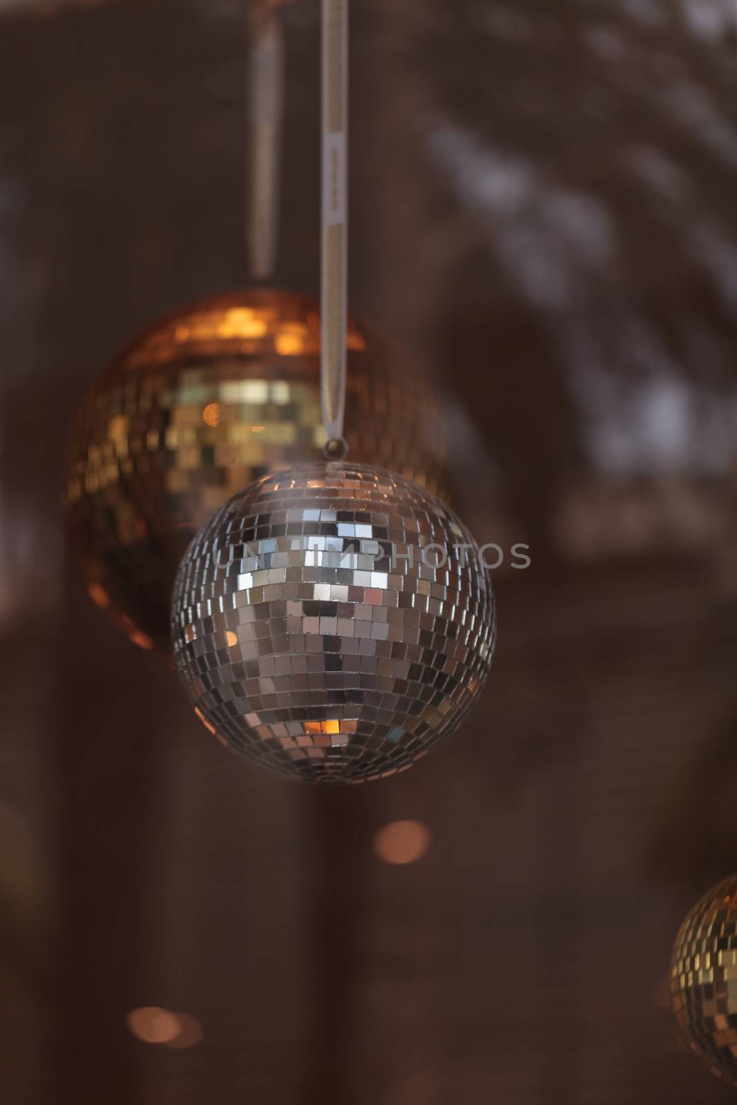 Silver and gold disco balls hang from the ceiling on New Years eve