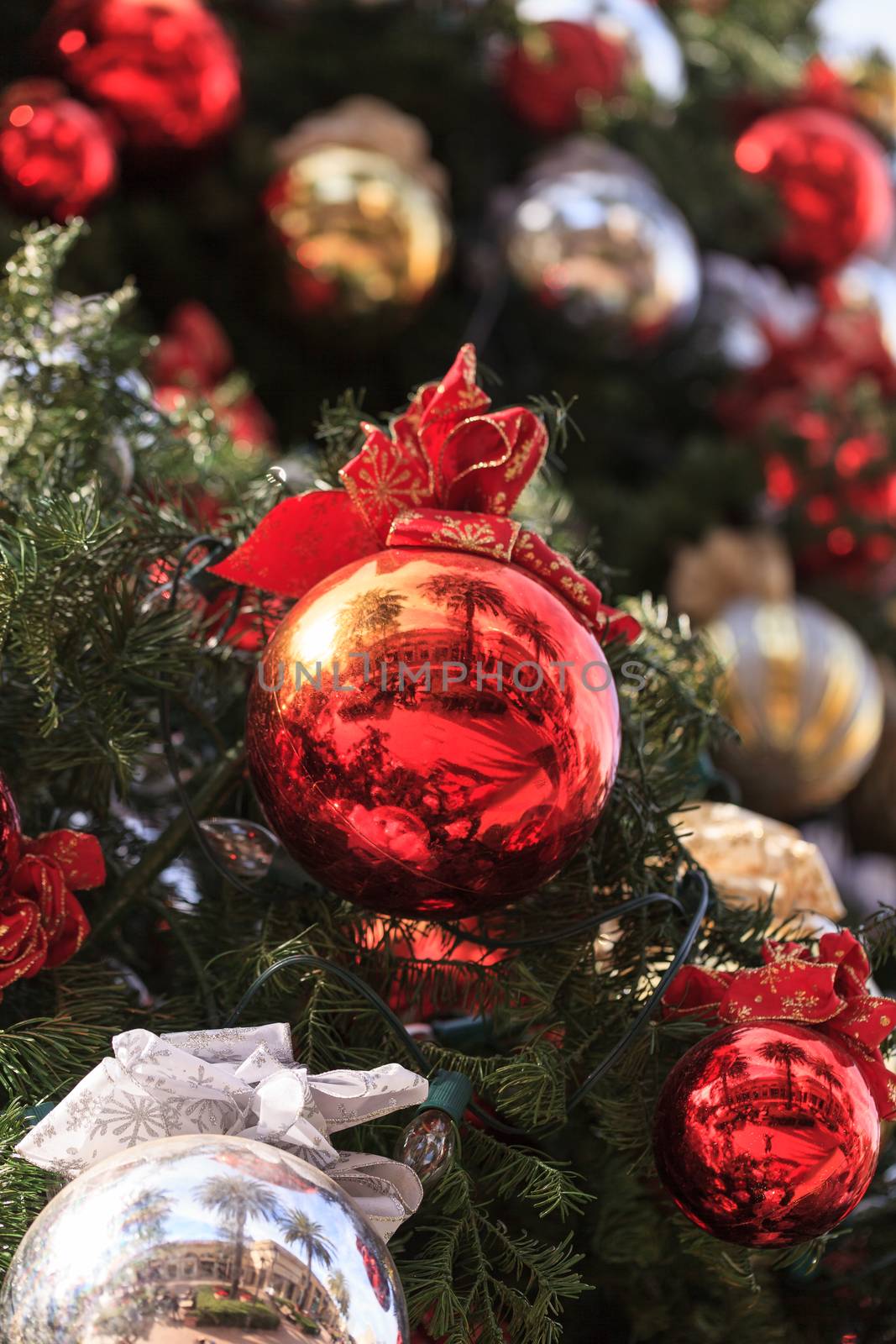 Red, green, gold, silver Christmas ornaments hanging on a Christmas tree in December