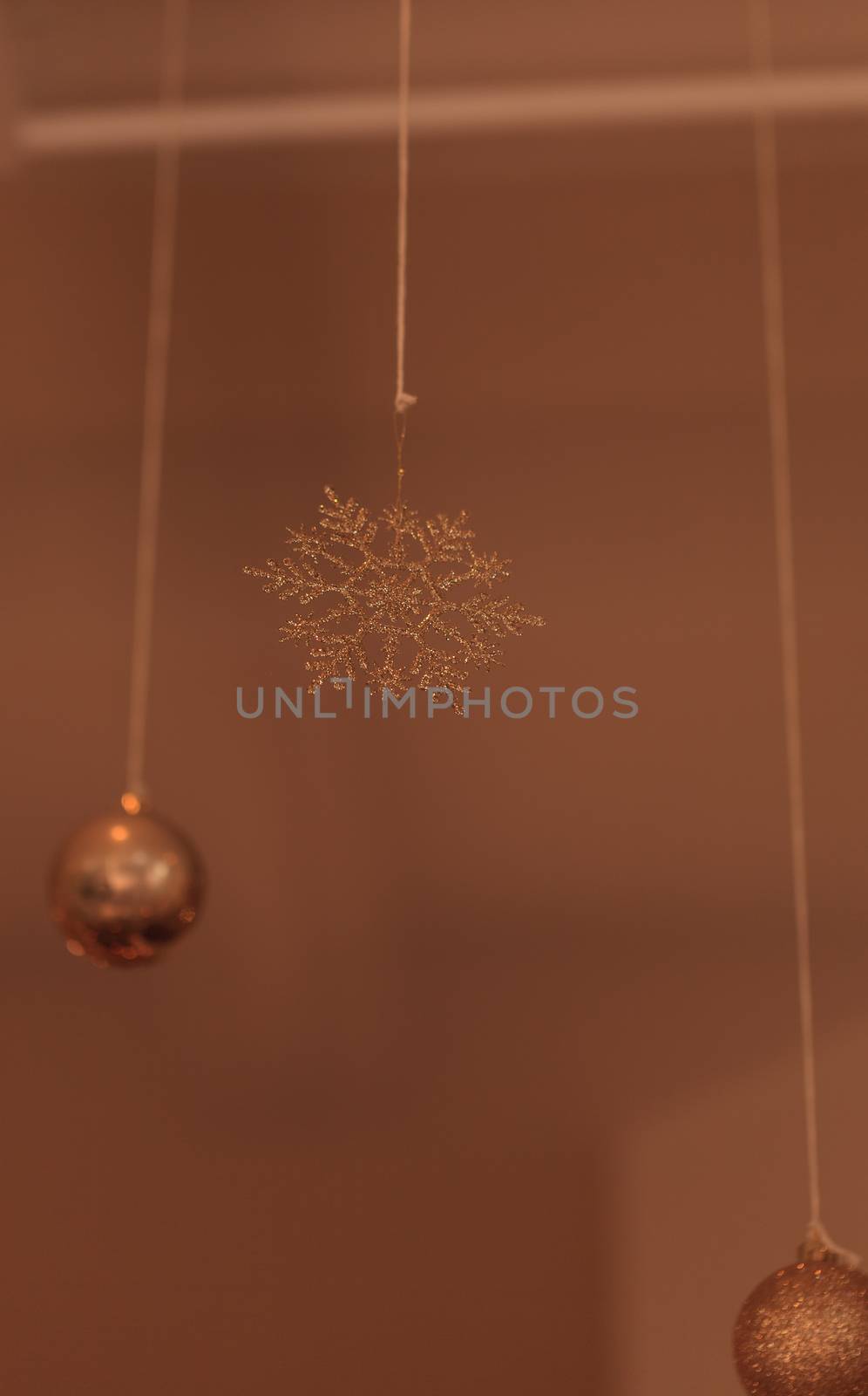 Gold silver Christmas ornament hanging from the ceiling in December