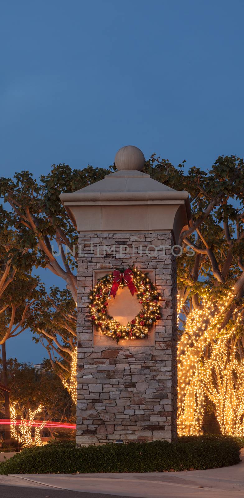 Christmas holiday wreath with white lights on a brick pillar