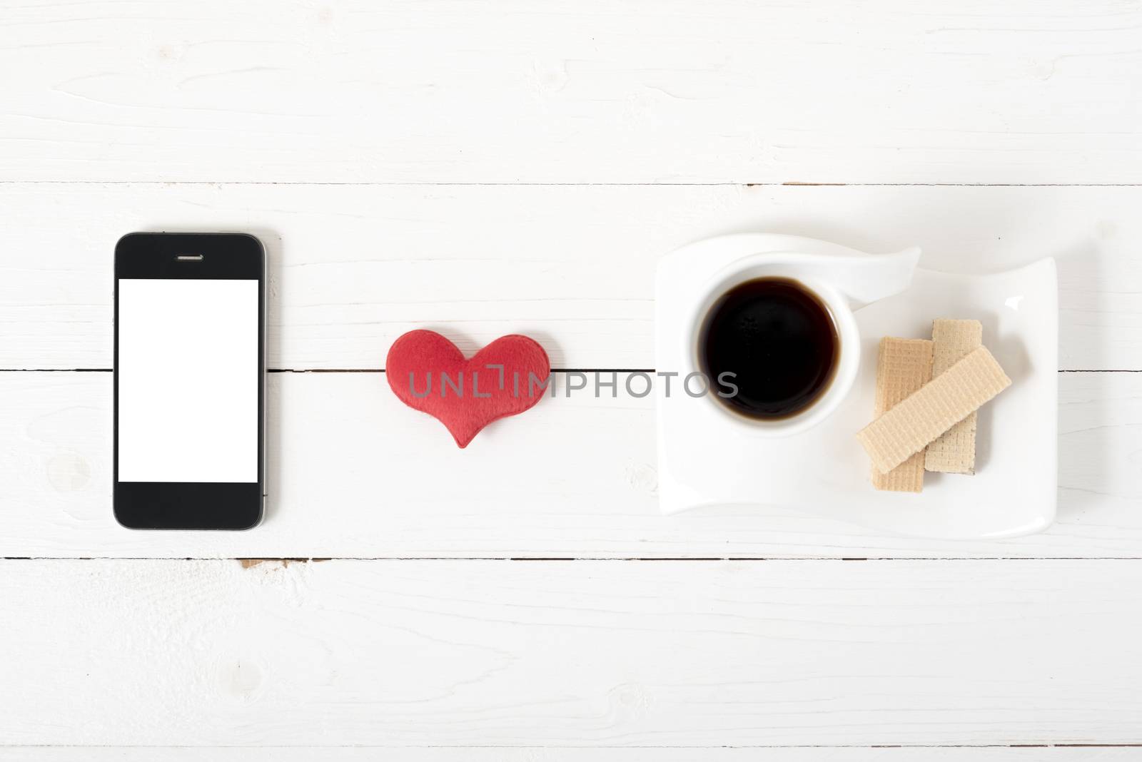 coffee cup with wafer,phone,heart on white wood background