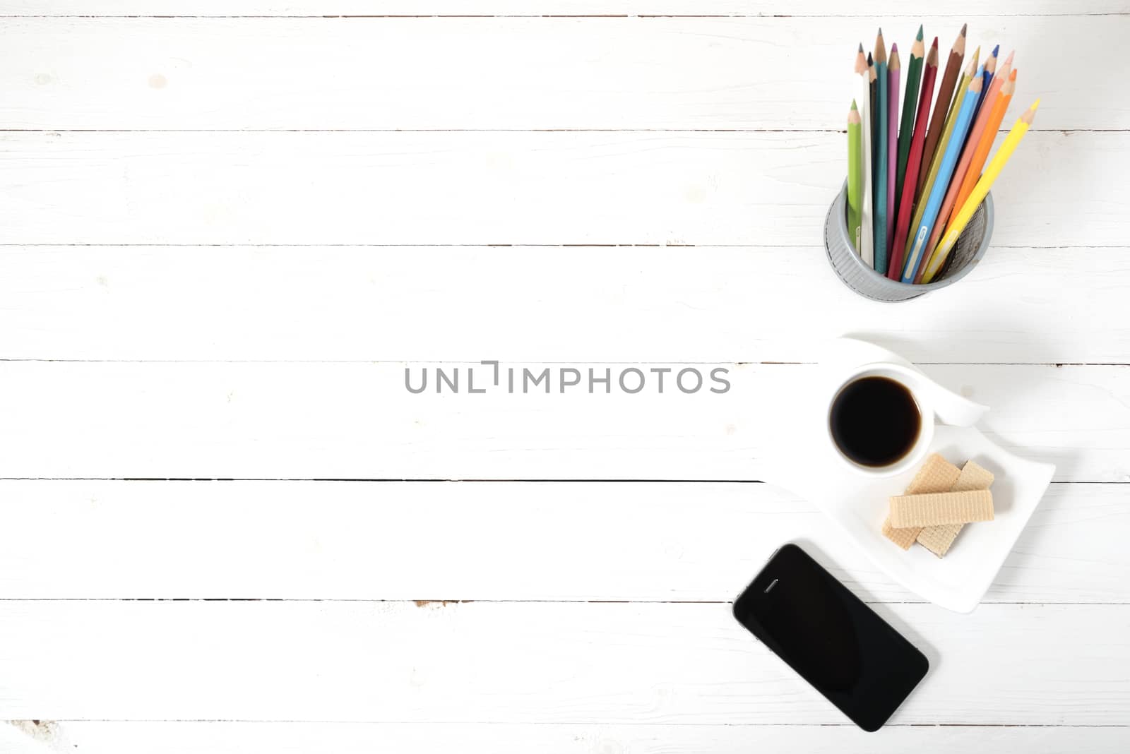 coffee cup with wafer,phone,pencil box on white wood background