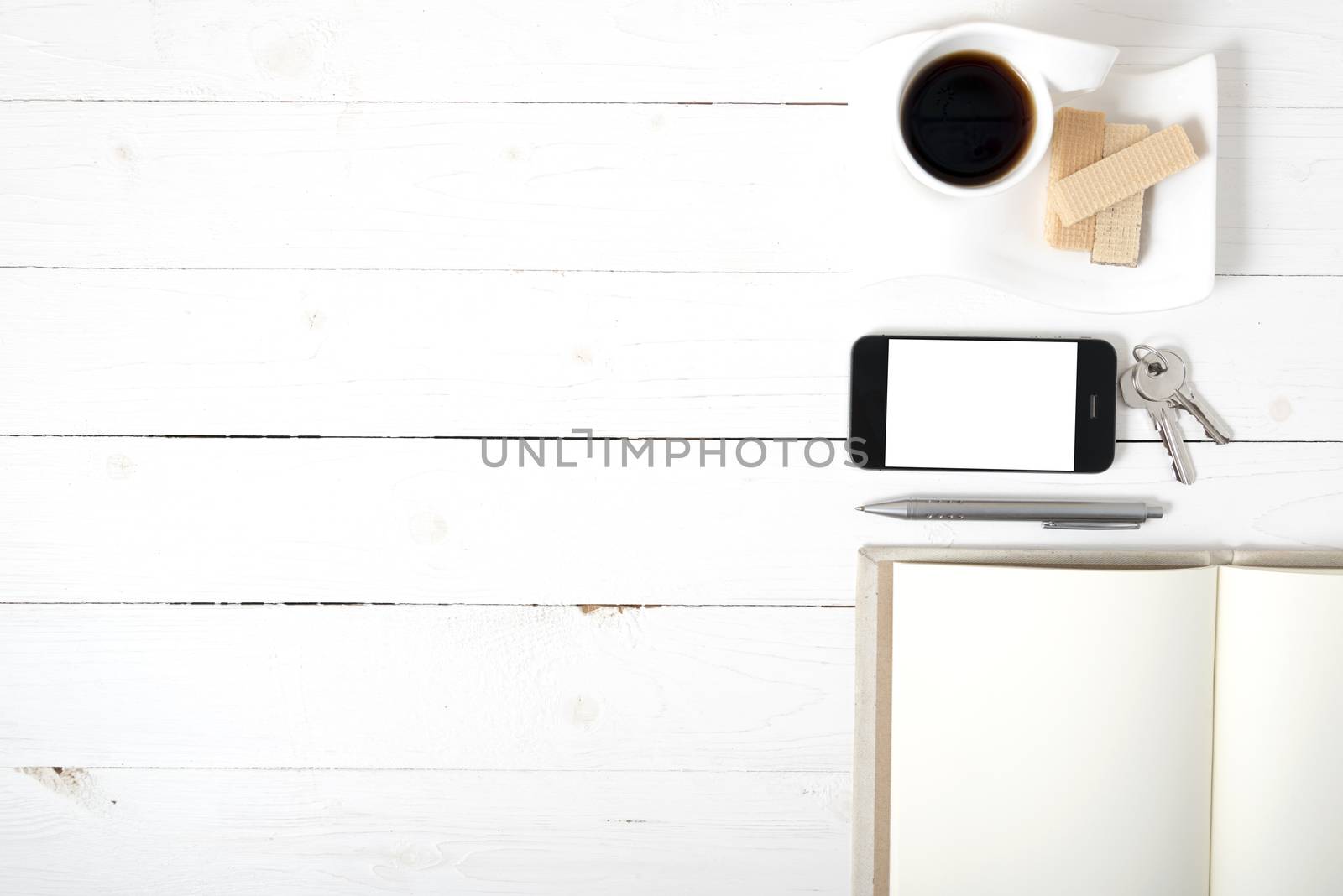 coffee cup with wafer,phone,key,notebook on white wood background