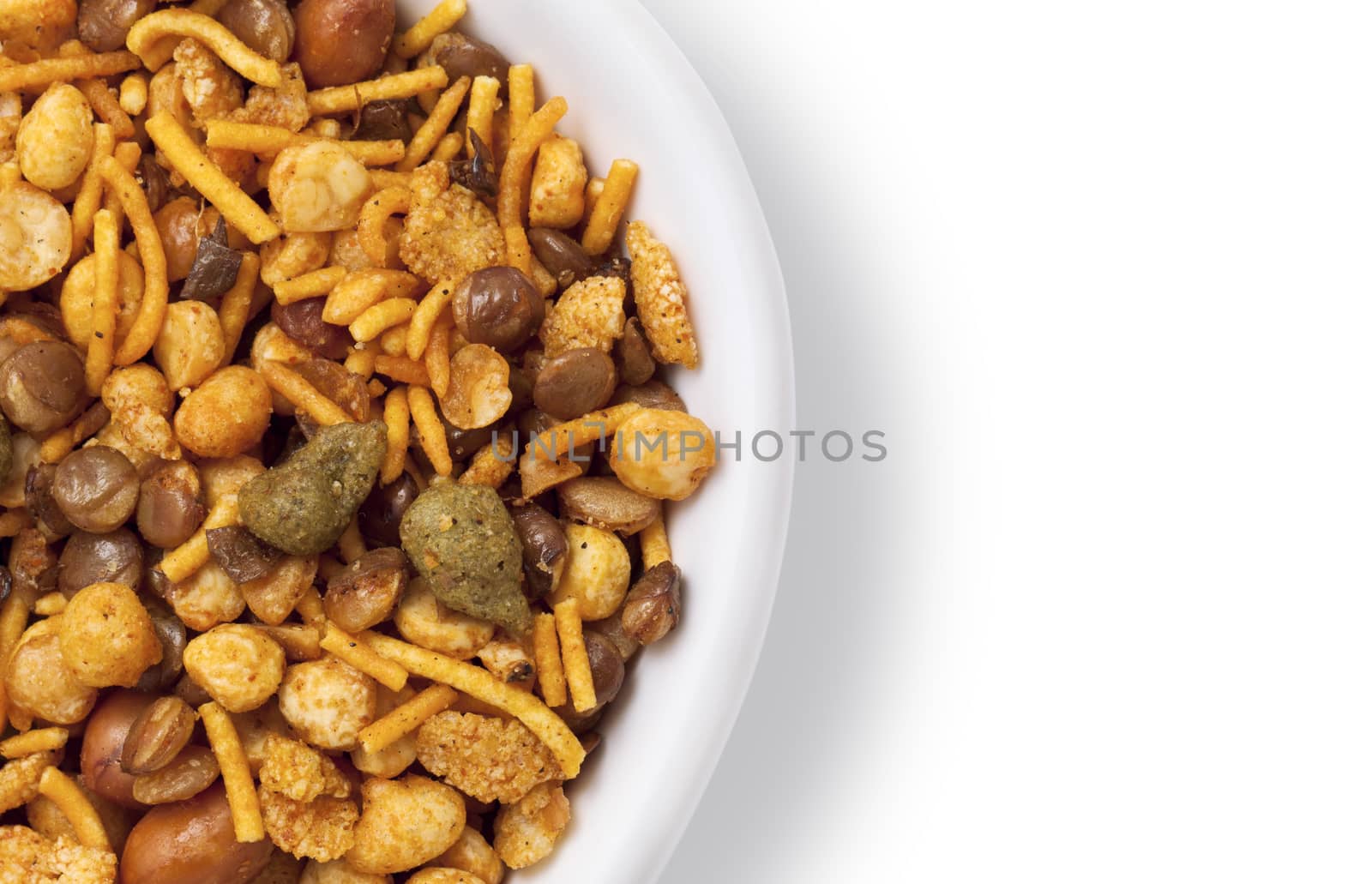 Dry roasted Indian snack mix in a big spoon, isolated