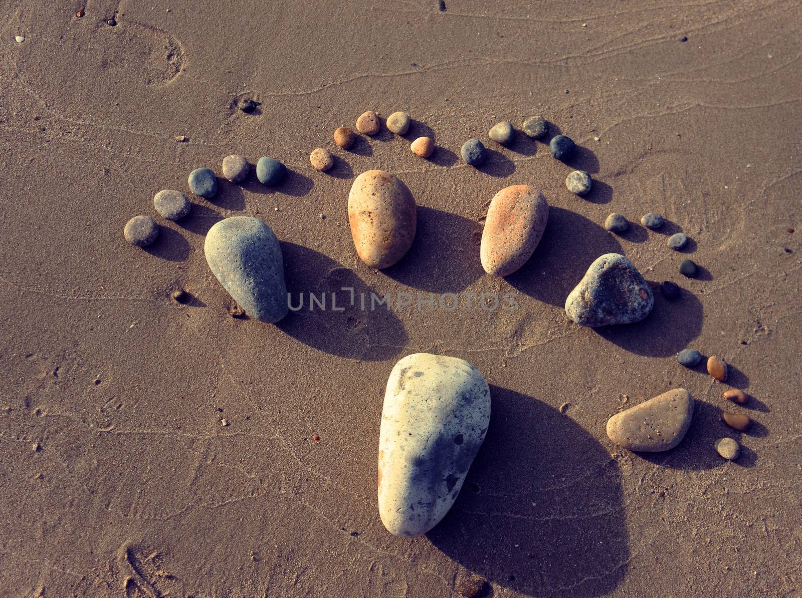 Group of foot by pebble on sand background, amazing concept from stone  with yellow color on beach, awesome art product