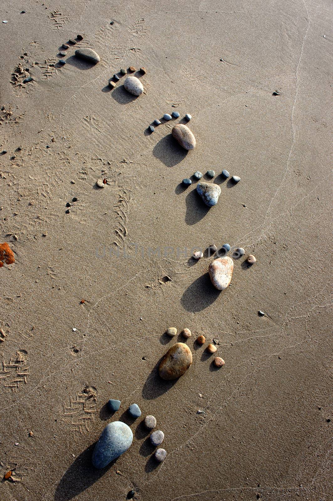 Group of foot by pebble on sand background, amazing concept from stone  with yellow color on beach, awesome art product