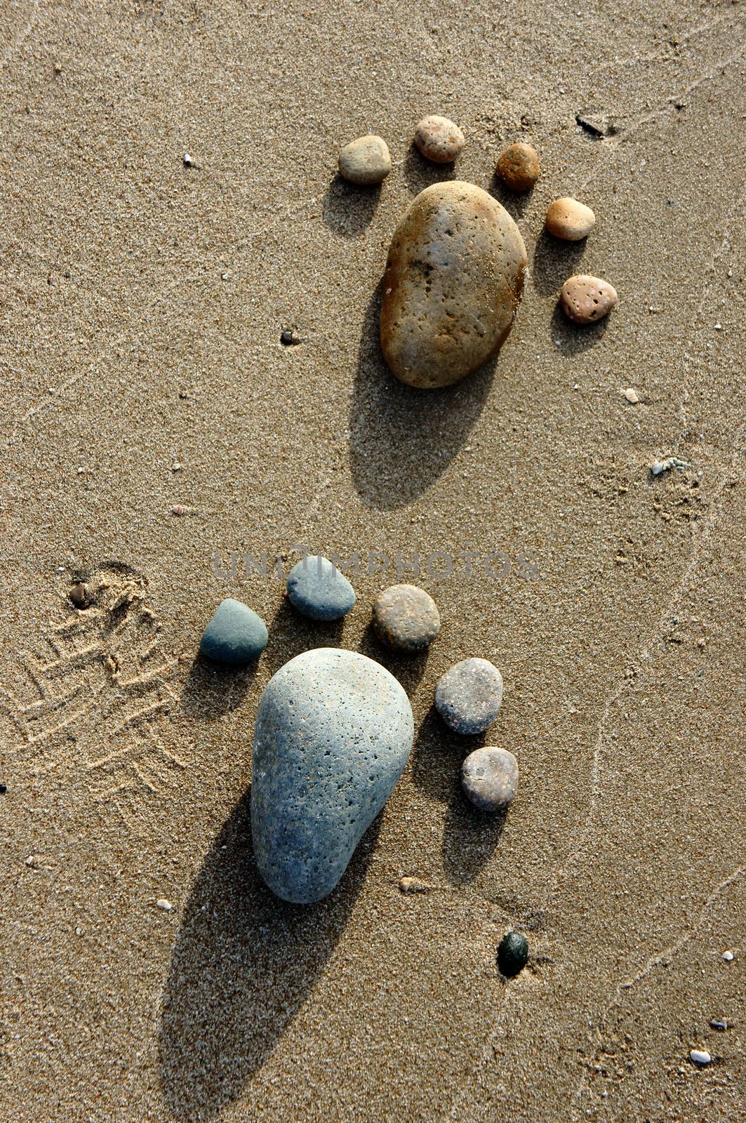 Group of foot by pebble on sand background, amazing concept from stone  with yellow color on beach, awesome art product