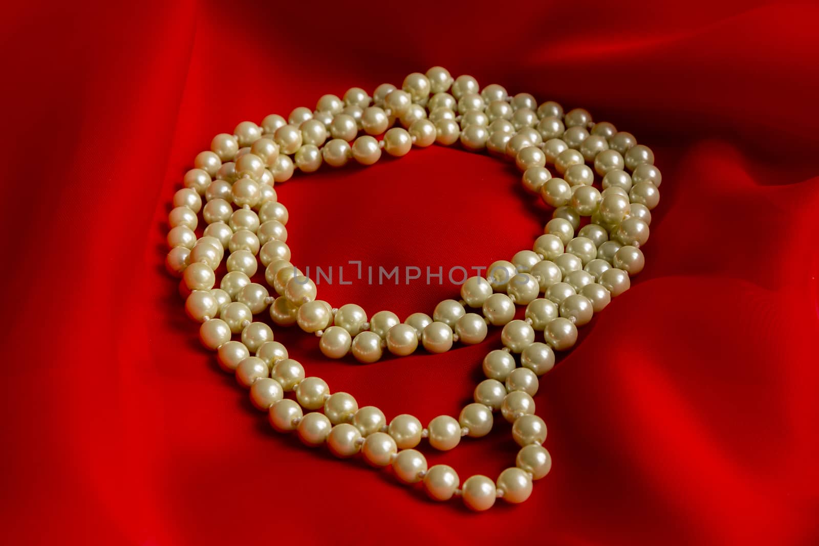 Pearl necklace on a red silk