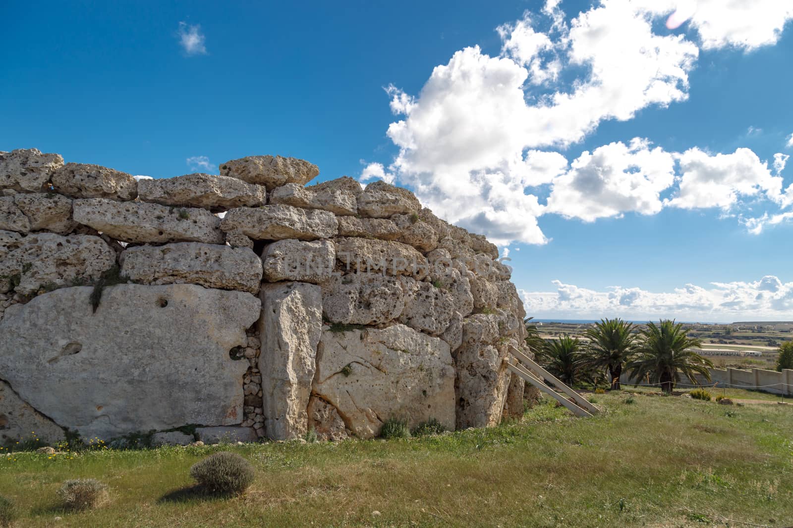 View of stone structures of ancient Ggantija Temples in Gozo Malta, on cloudy blue sky background.