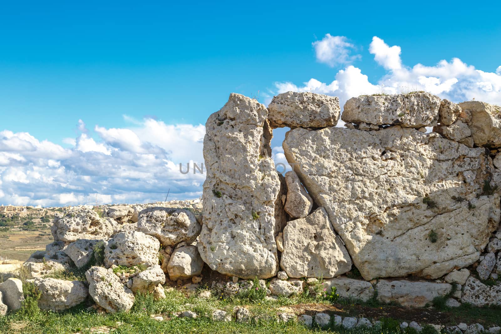 View of stone structures of ancient Ggantija Temples in Gozo Malta, on cloudy blue sky background.