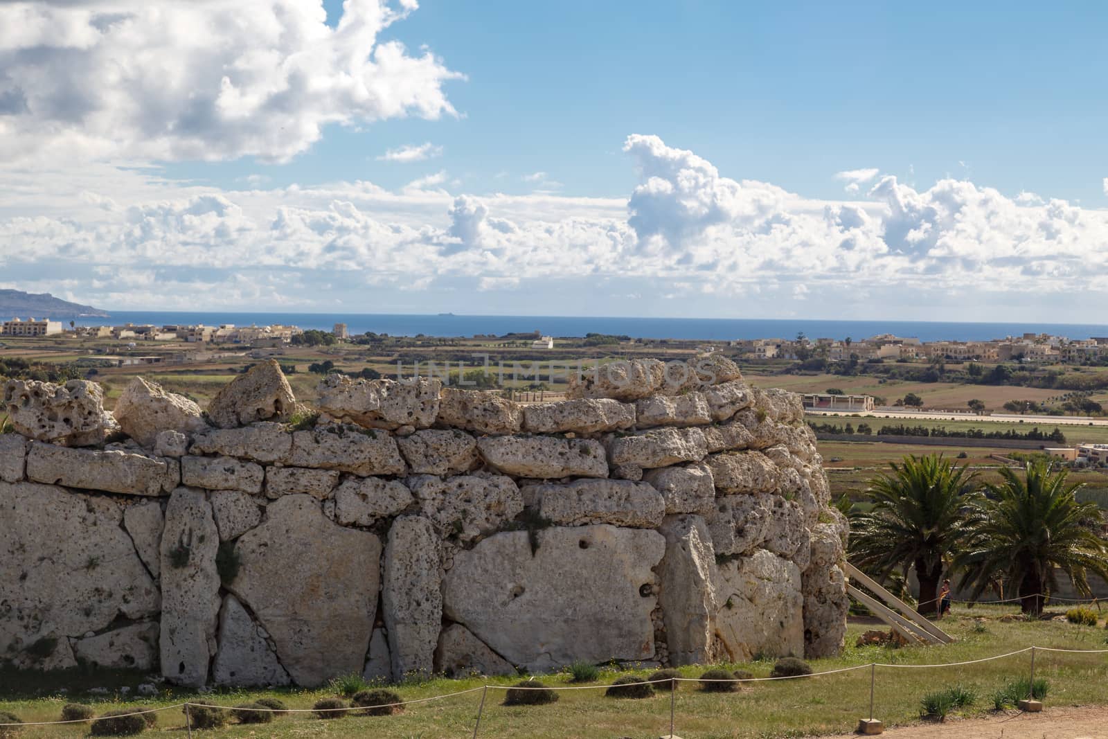 View of stone structures of ancient Ggantija Temples in Gozo Malta, on cloudy blue sky background.