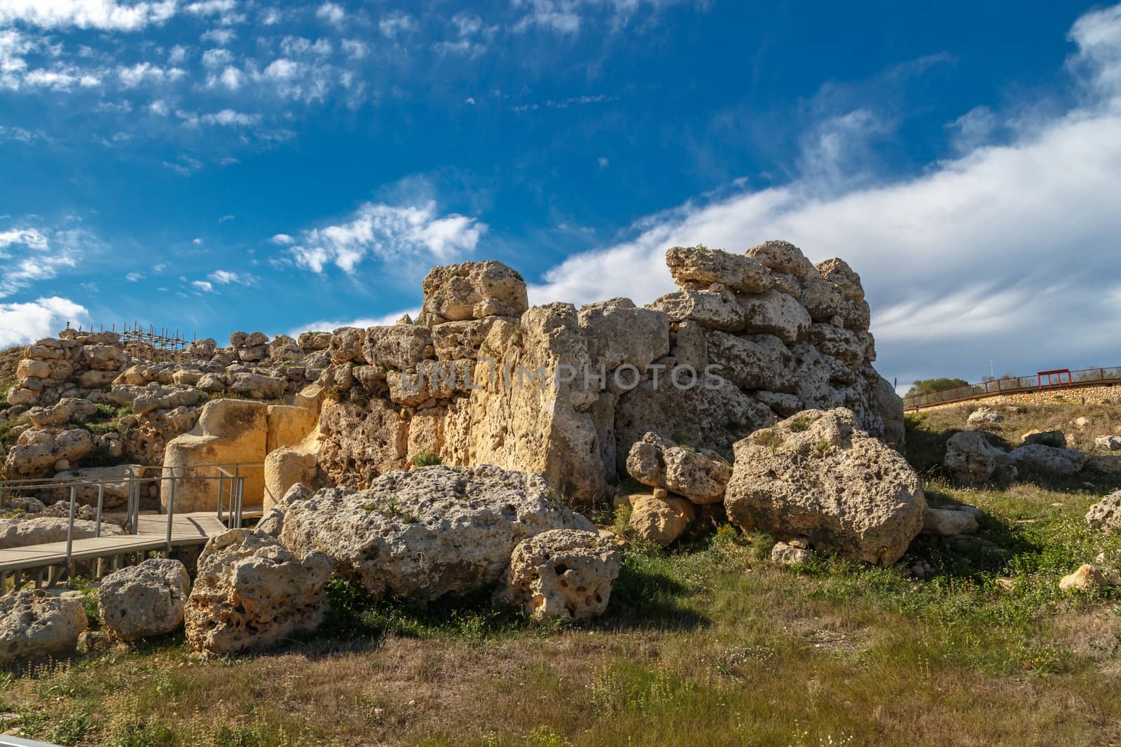 View of stone structures of ancient Ggantija Temples in Gozo Malta, on cloudy blue sky background.