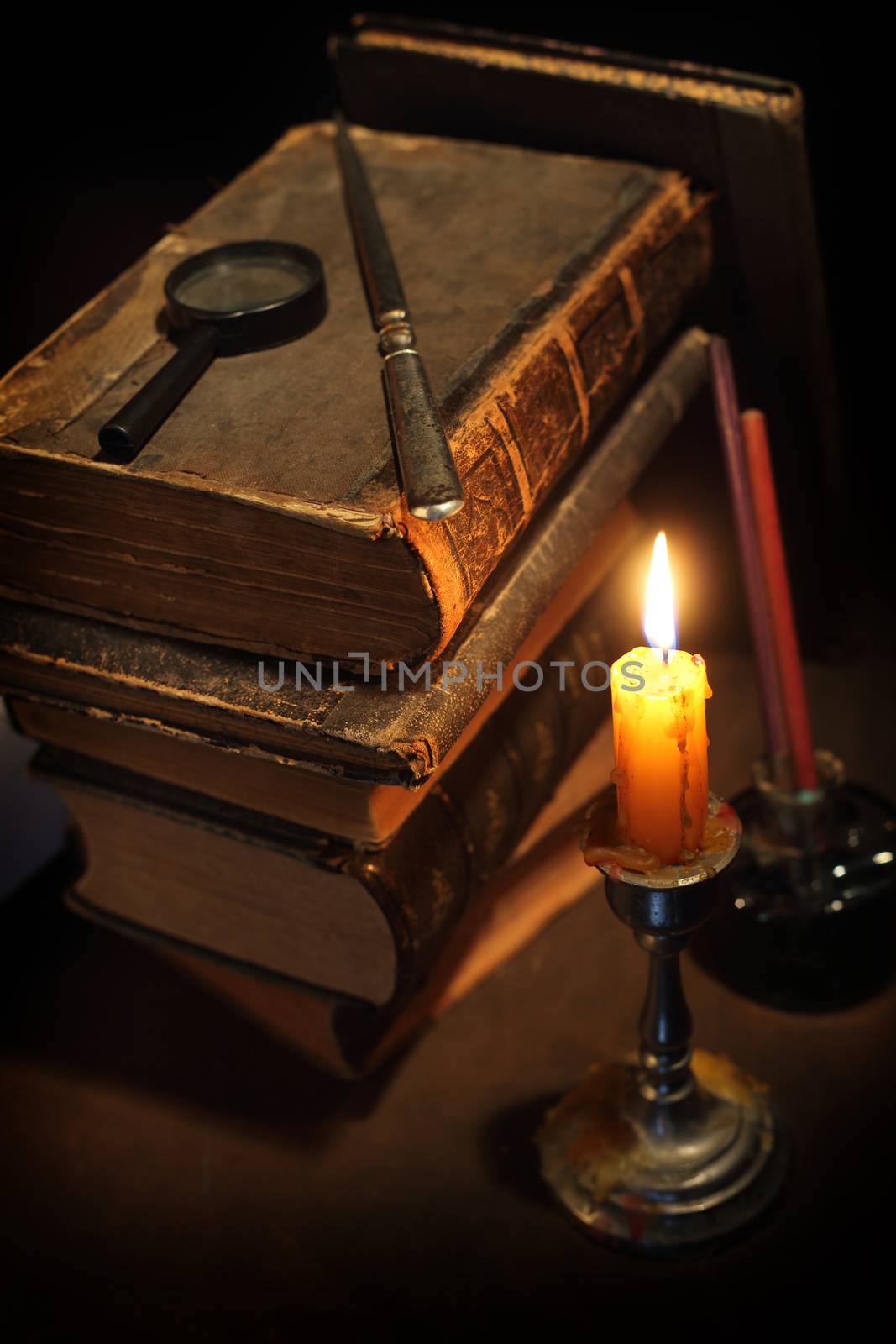 Pile of the old books and a candle