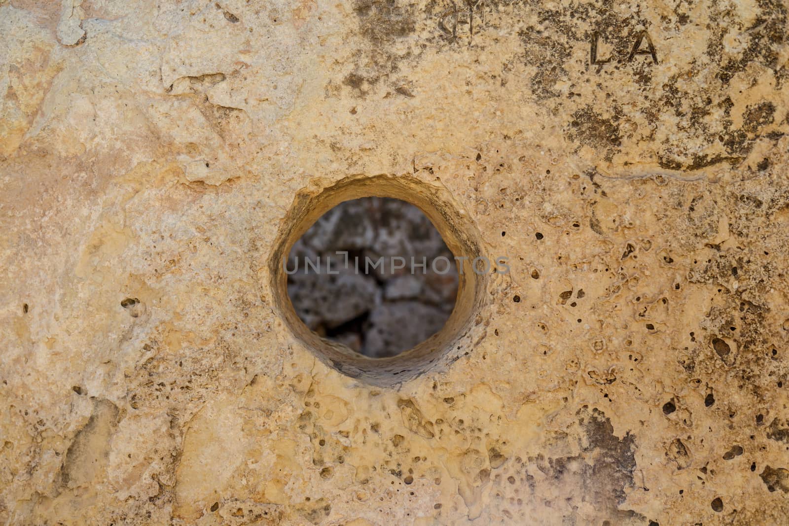 Close up detailed view of small round shape hole on a stone.