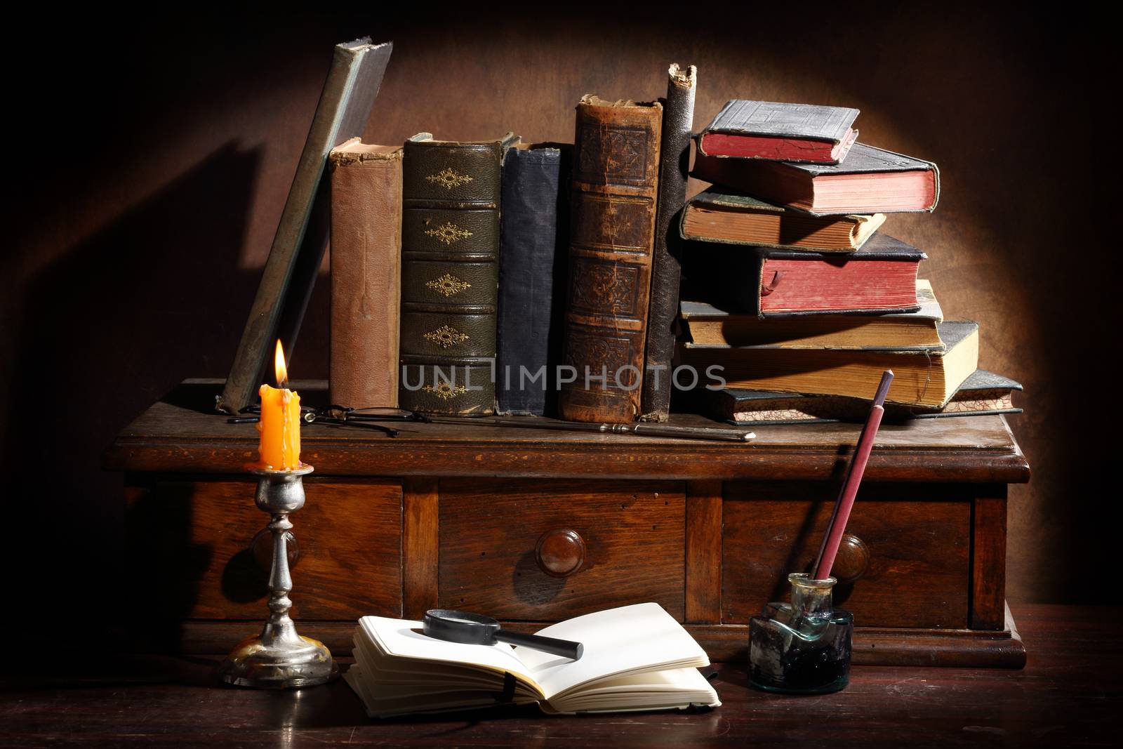 Pile of the old books and a magnifier