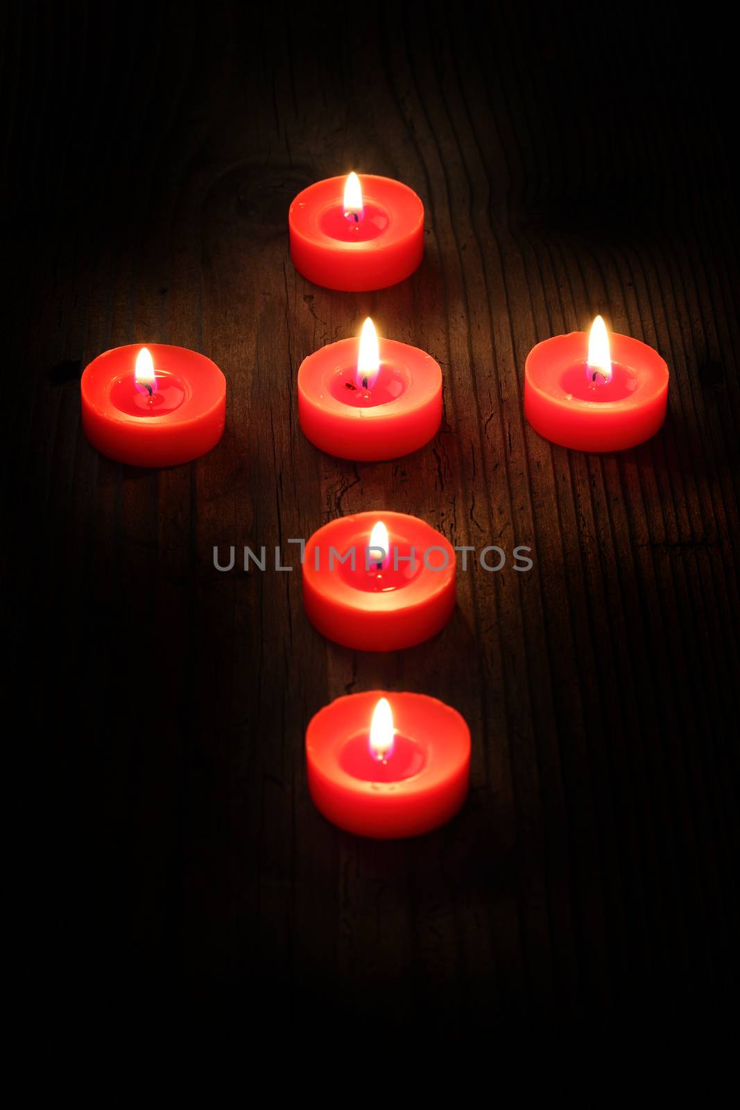 burning  candles arranged in a cross, shallow dof