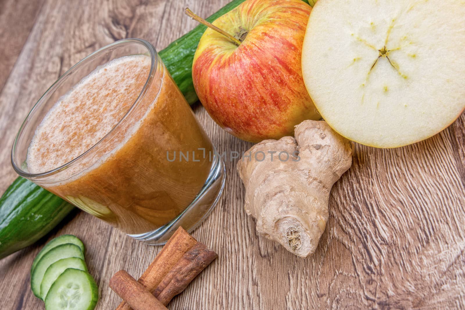 Blended fruit smoothie with ingredients on wooden table