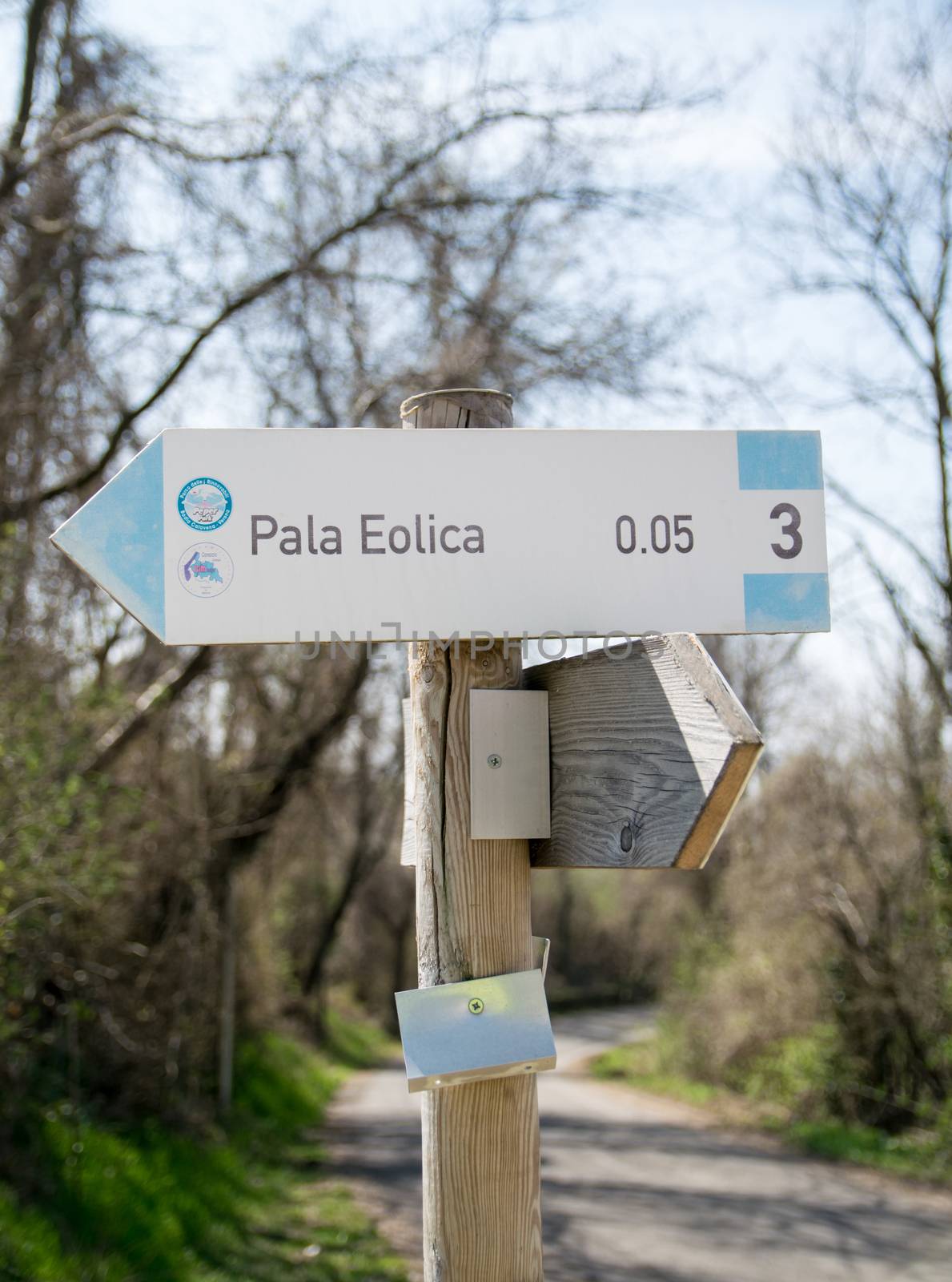 Wooden street sign showing the direction to a wind farm. by Isaac74