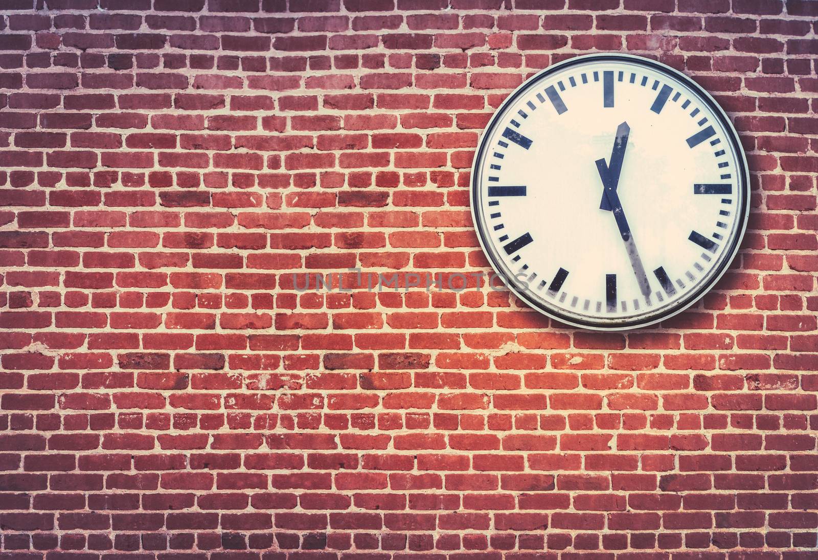 Retro Railway Style Clock Against A Red Brick Wall