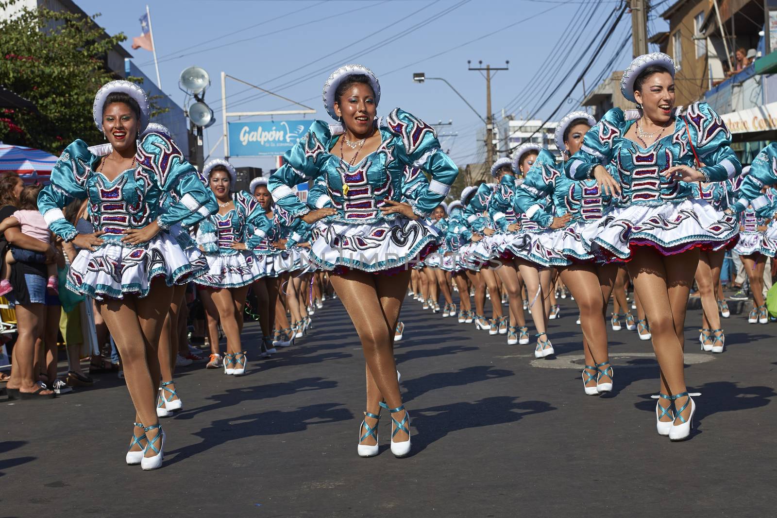 Female members of a Caporales dance group in ornate costumes performing at the annual Carnaval Andino con la Fuerza del Sol in Arica, Chile.