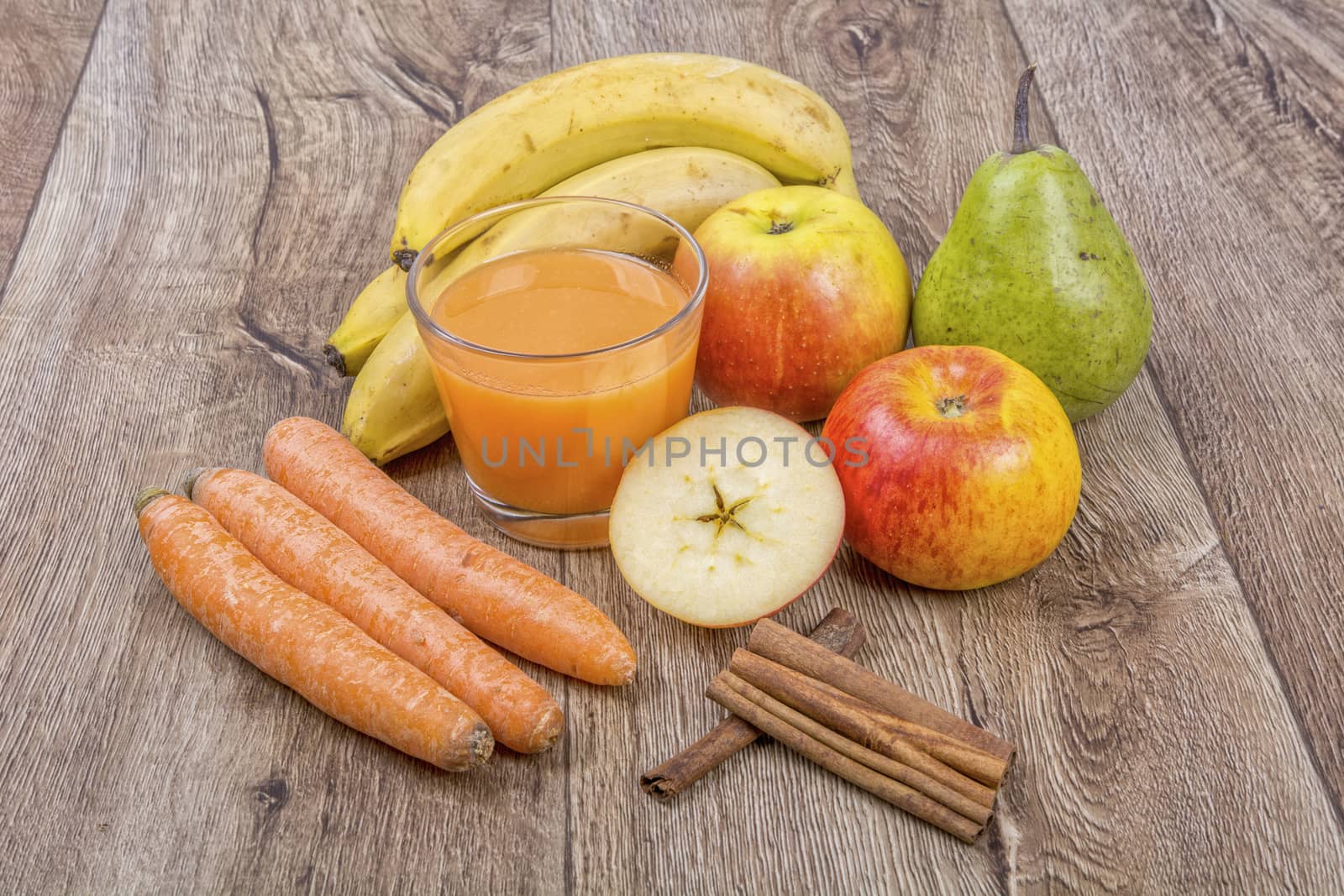Blended fruit smoothie with ingredients on wooden table