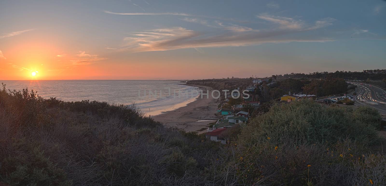 Cottages along Crystal Cove Beach, on the Newport Beach and Laguna Beach line in Southern California at sunset with a rainstorm looming.