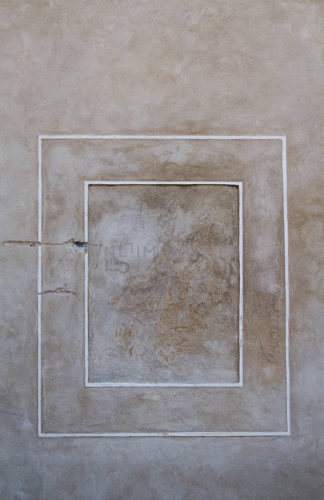 Grey-brown color of the wall, original color of the facade and concrete, with contrast white double frame in a renaissance style.