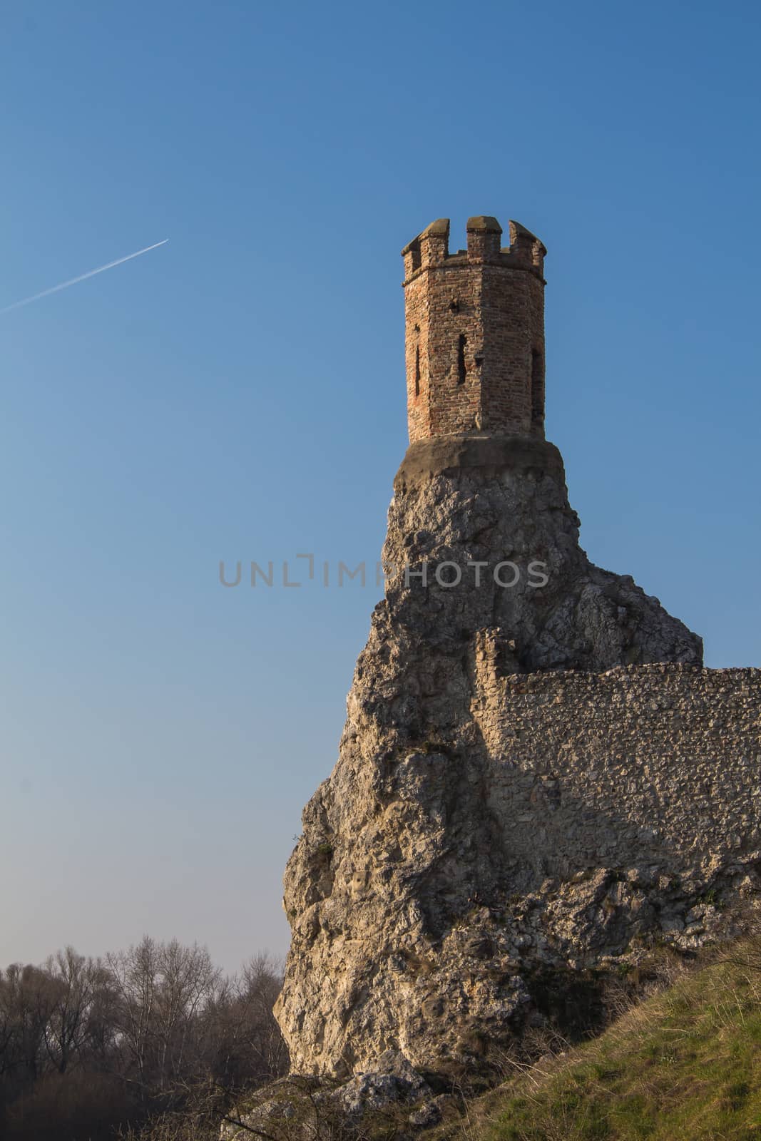 Rocks of the former fortress with a Maiden Tower, part of ruins of castle and fortress Devin in Slovakia. Bright blue sky.