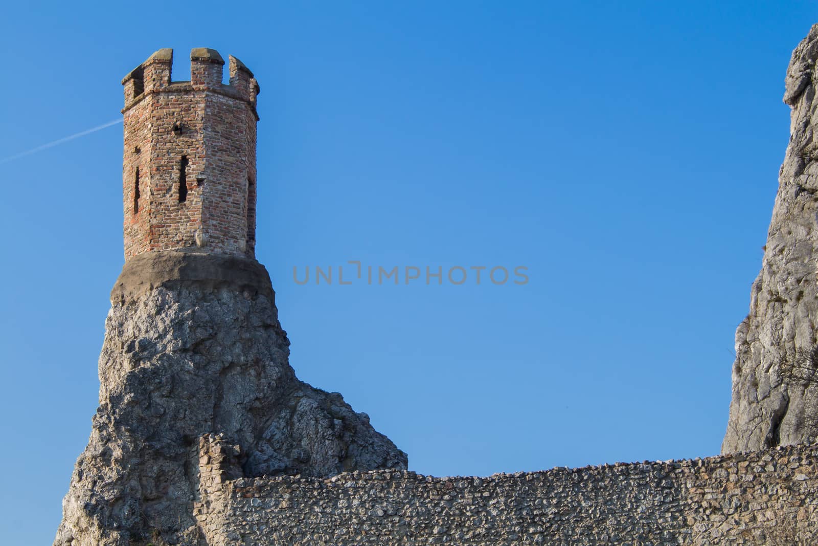 Rocks of the former fortress with a Maiden Tower, part of ruins of castle and fortress Devin in Slovakia. Bright blue sky.