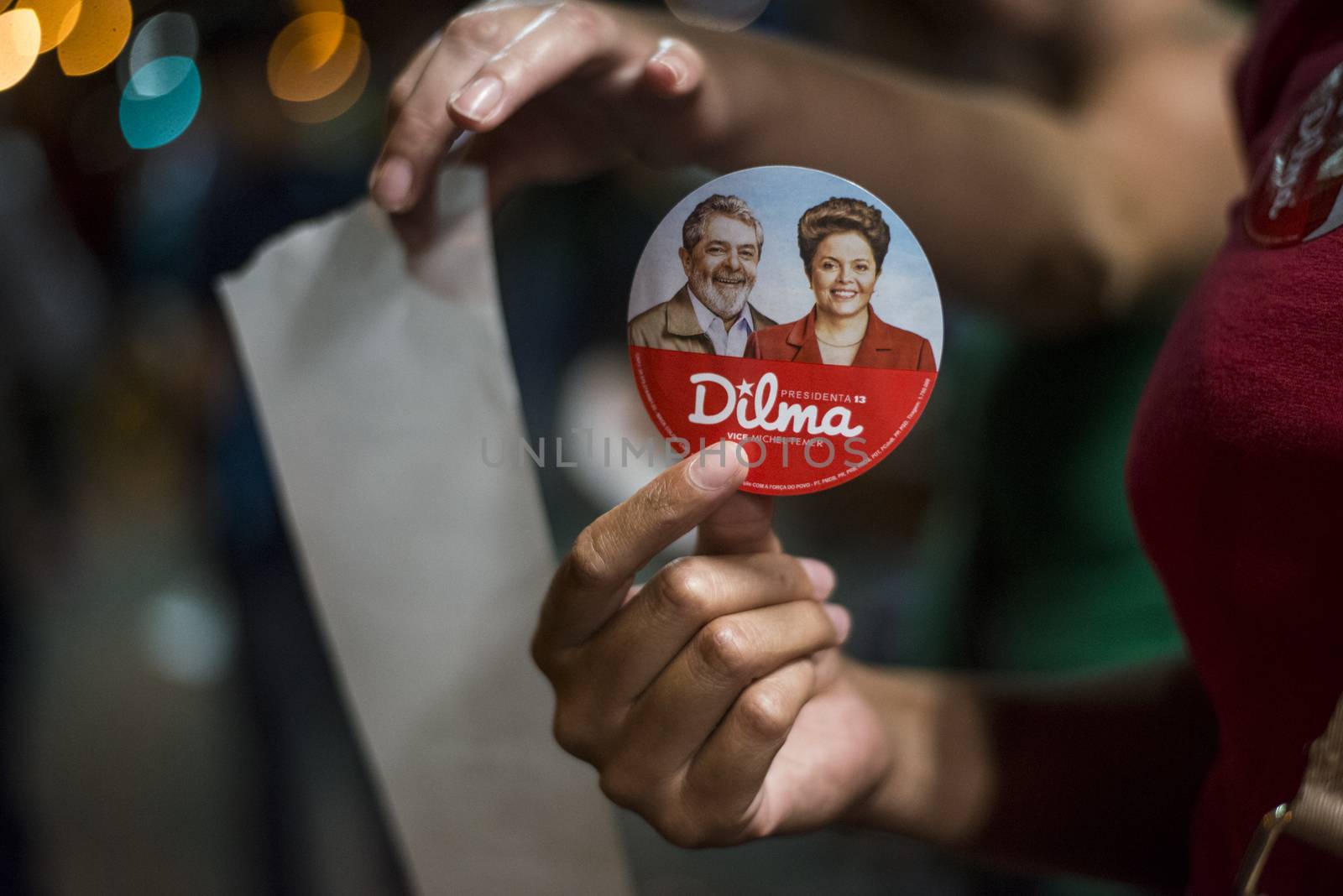 BRAZIL, Curitiba: A pro-government protester holds a badge with the efffigy of President Dilma Rousseff and former President Luiz Inacio Lula da Silva during a demonstration in support of President Dilma Rousseff and former President Luiz Inacio Lula da Silva in Curitiba, Brazil, on March 18, 2016. Brazilian President Dilma Rousseff's supporters took to the streets Friday to fight back at attempts to oust her, as a flurry of court battles raged over her controversial cabinet appointment of predecessor Luiz Inacio Lula da Silva. 