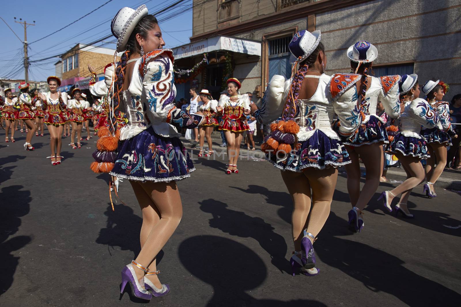 Caporales dancers in ornate blue and white costumes performing at the annual Carnaval Andino con la Fuerza del Sol in Arica, Chile.