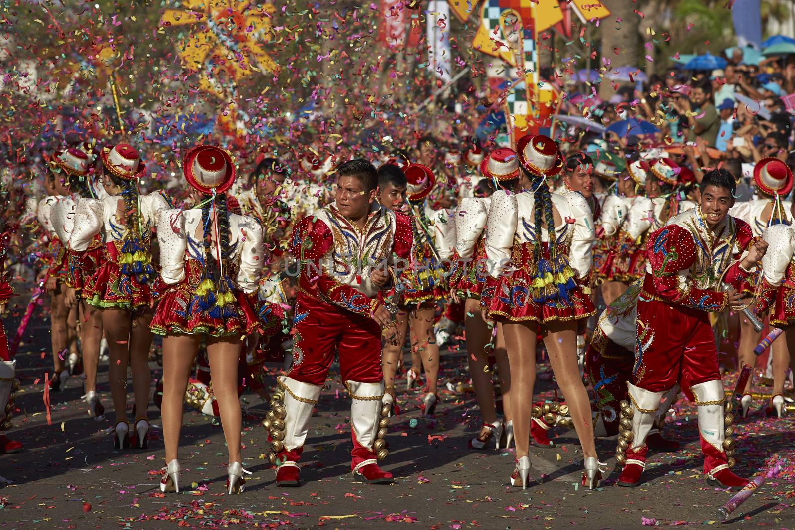 Caporales dance group in ornate red and white costumes performing at the annual Carnaval Andino con la Fuerza del Sol in Arica, Chile.