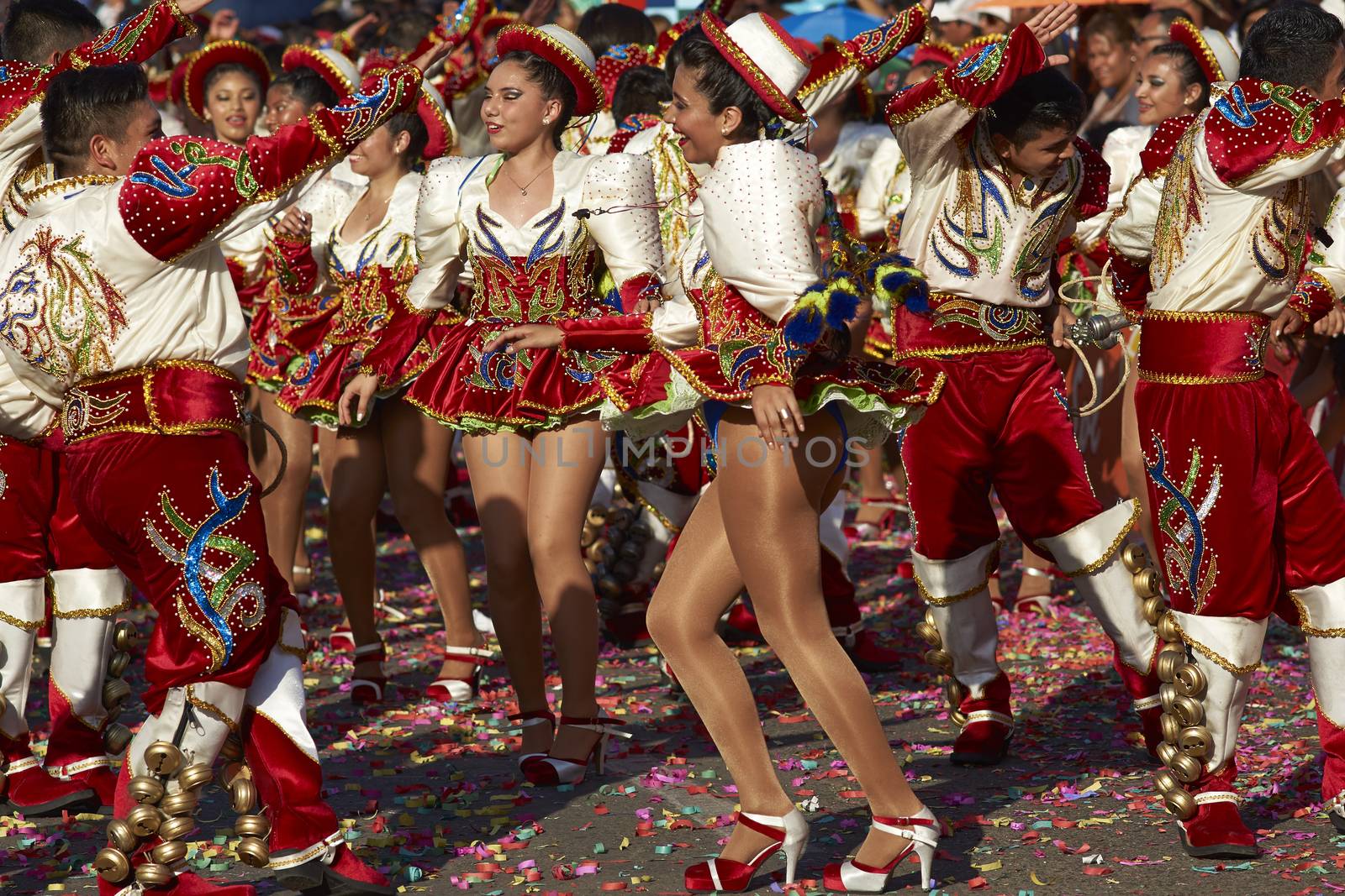 Caporales dance group in ornate red and white costumes performing at the annual Carnaval Andino con la Fuerza del Sol in Arica, Chile.