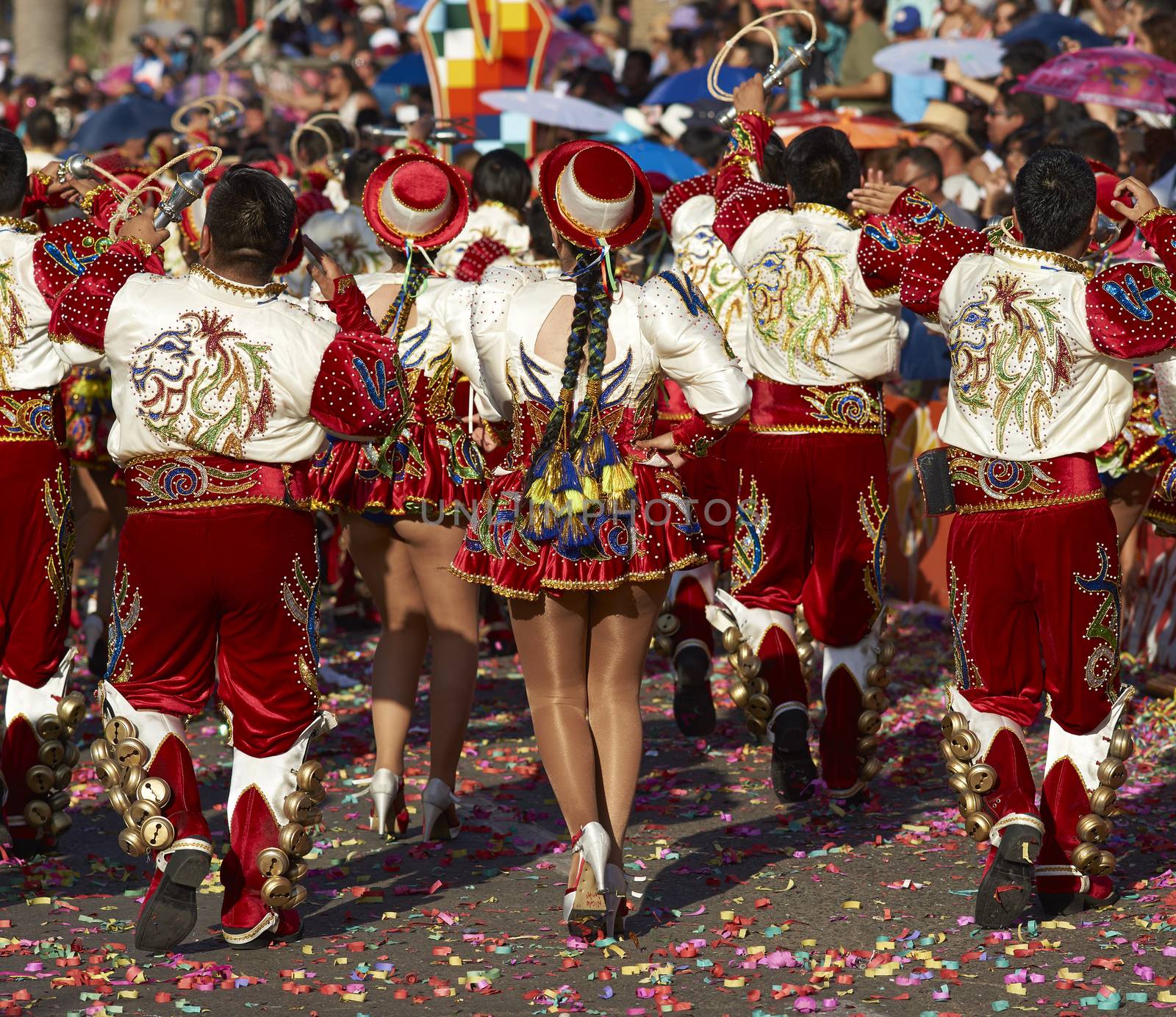 Caporales dance group in ornate red and white costumes performing at the annual Carnaval Andino con la Fuerza del Sol in Arica, Chile.