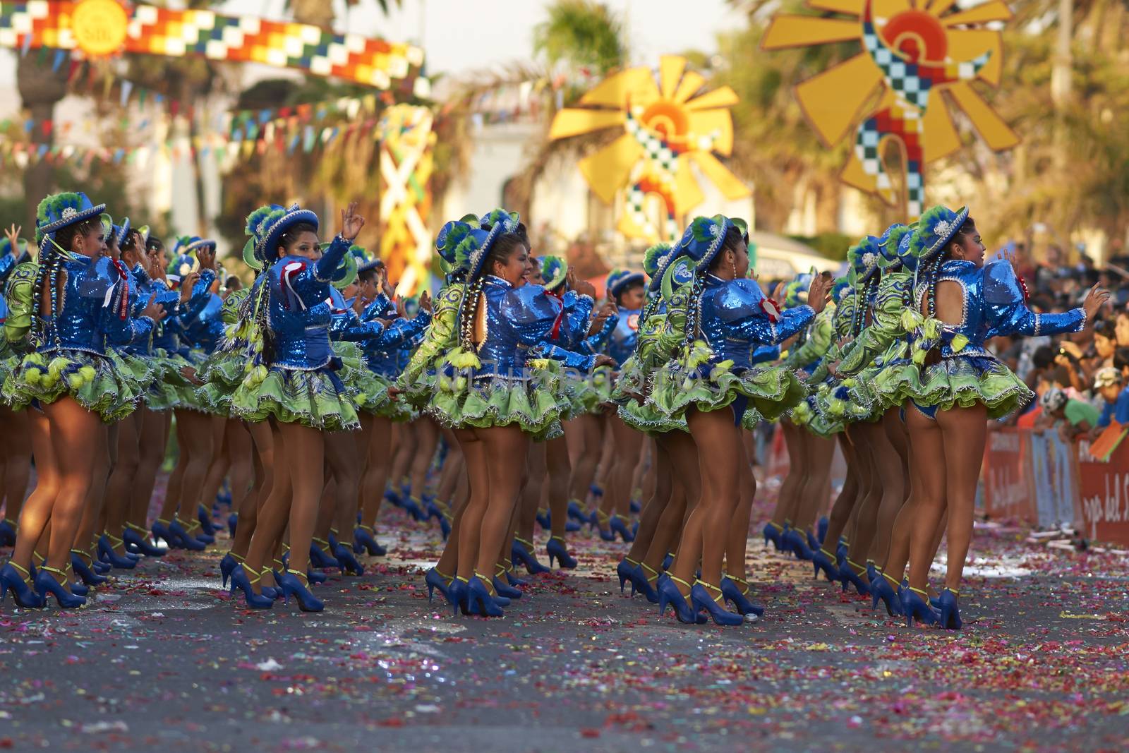 Female members of a Caporales dance group in ornate green and blue costumes performing at the annual Carnaval Andino con la Fuerza del Sol in Arica, Chile.
