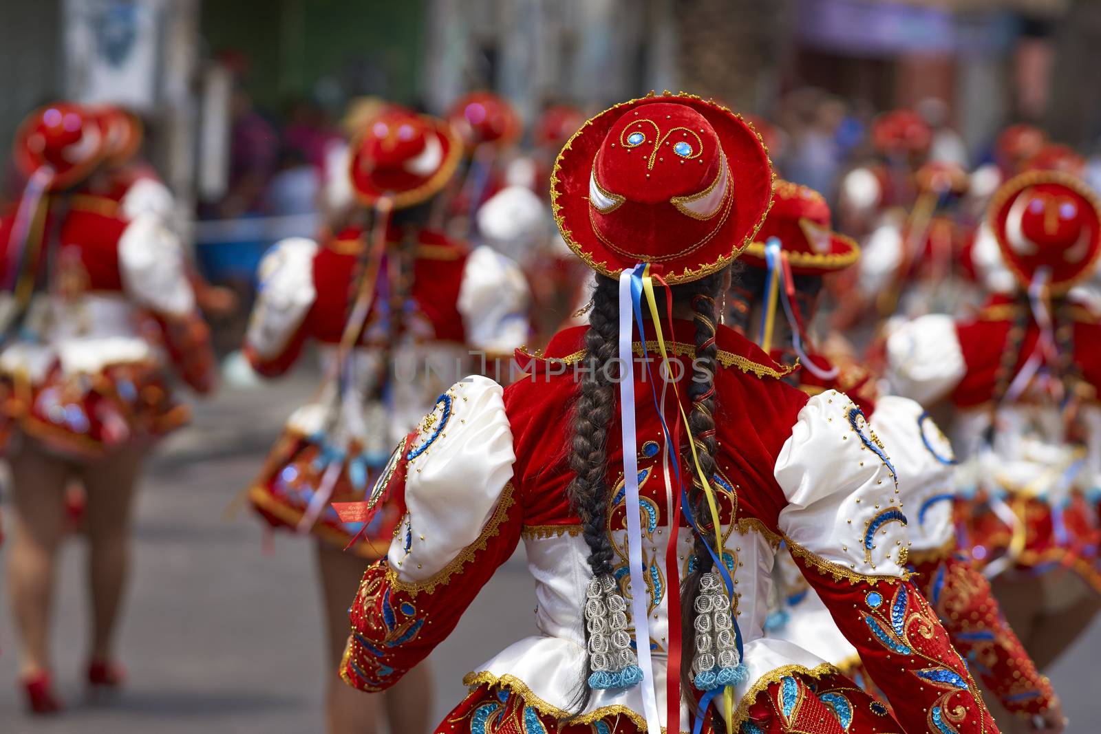 Caporales dancer in ornate red and white costume performing at the annual Carnaval Andino con la Fuerza del Sol in Arica, Chile.