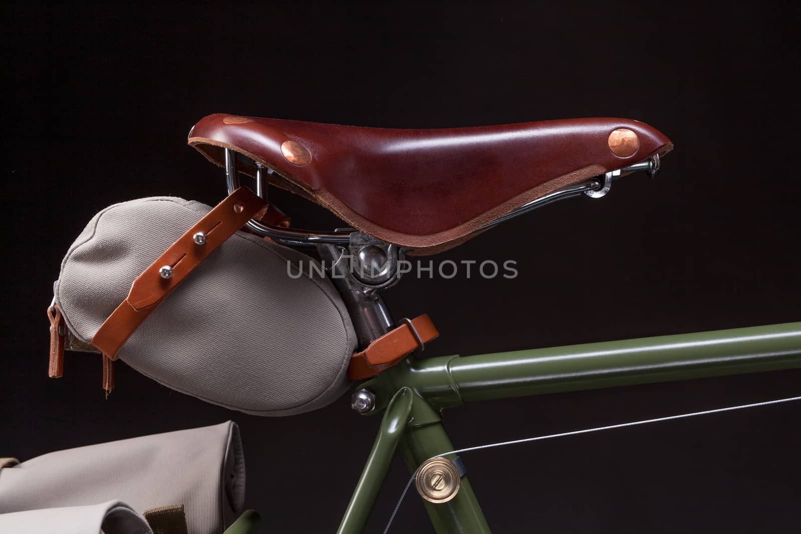 Vintage road bicycle saddle with under saddle bag, isolated on black.